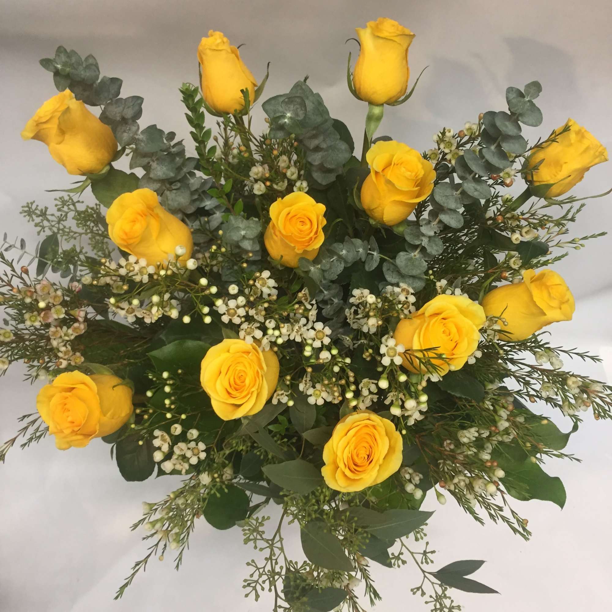 Bouquet of yellow roses with eucalyptus and small white filler flowers