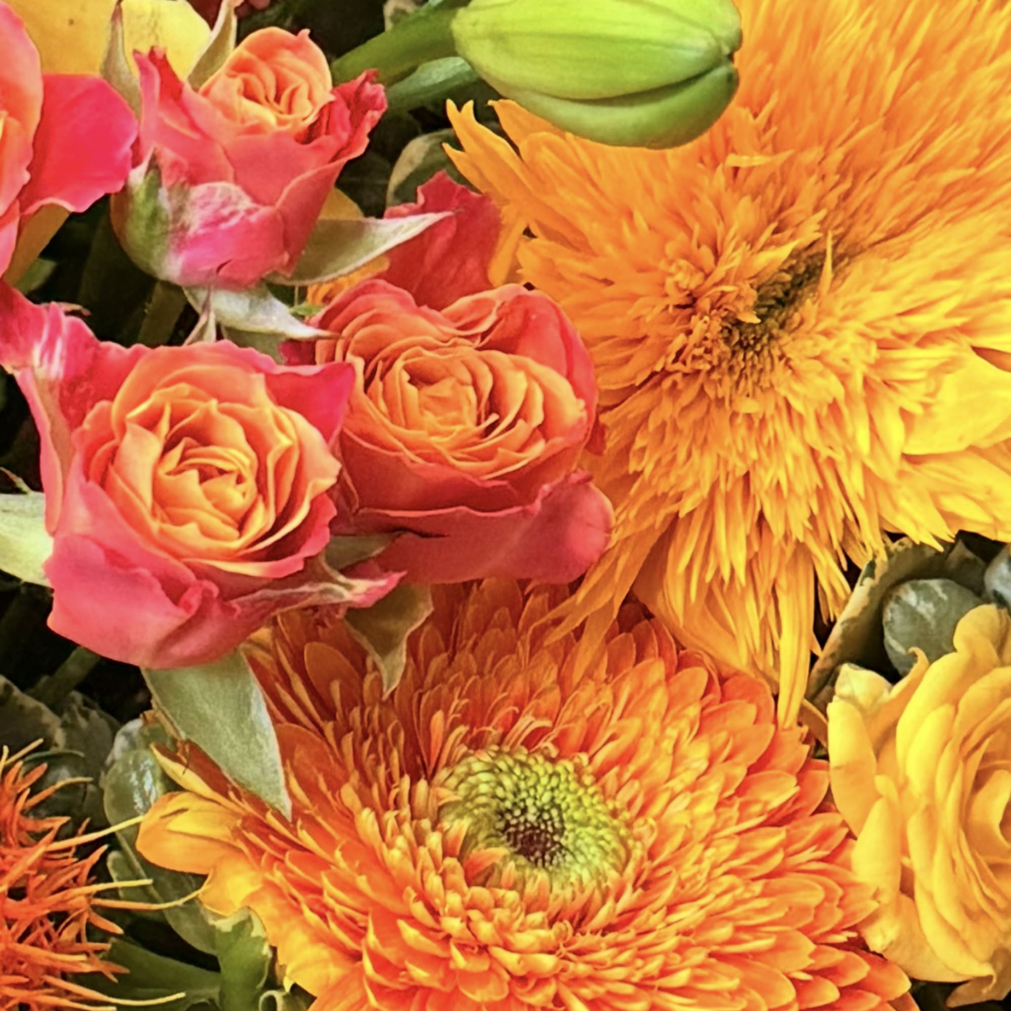 Bright mixed bouquet with orange and yellow blooms and pink roses