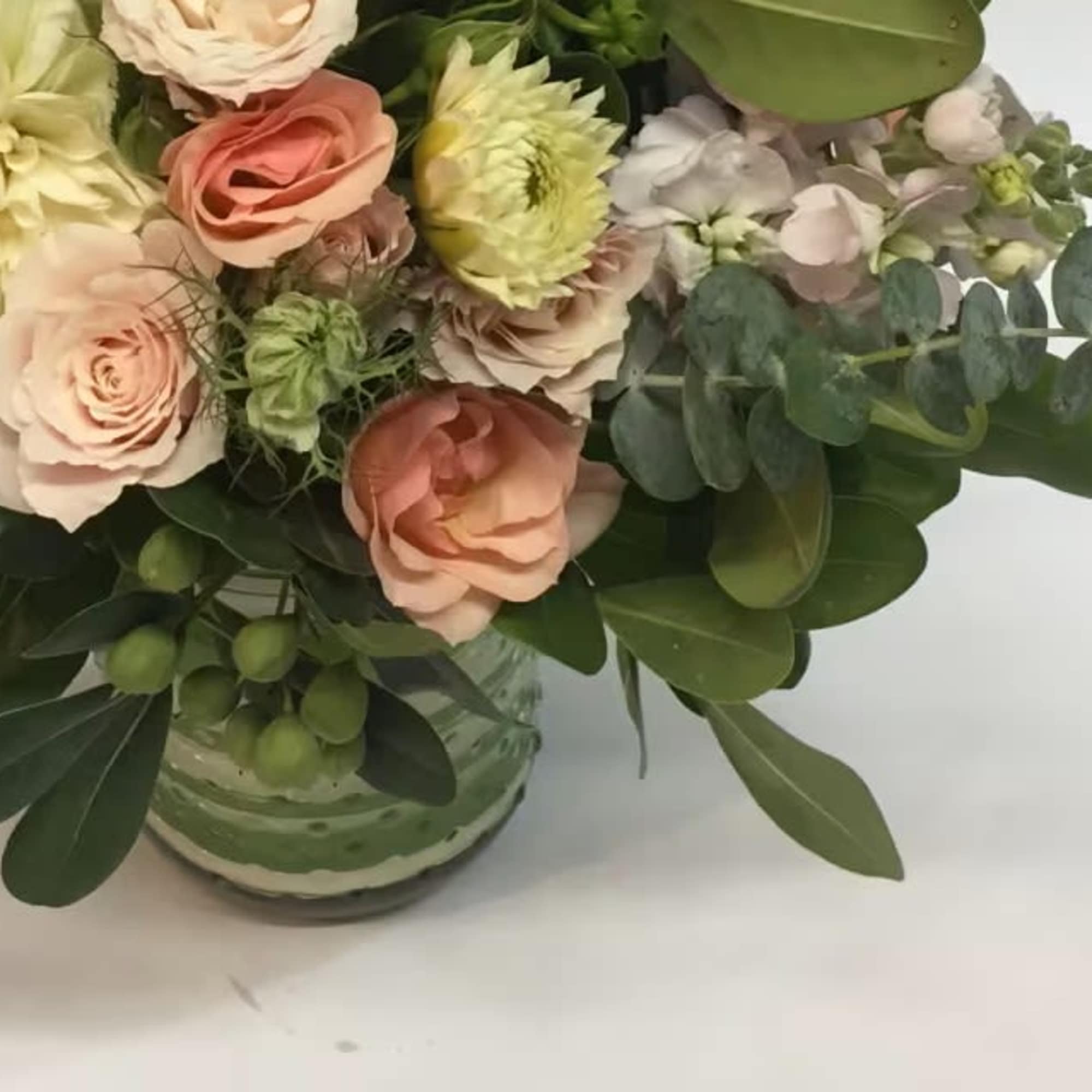 Bouquet of blush and cream flowers in a glass vase