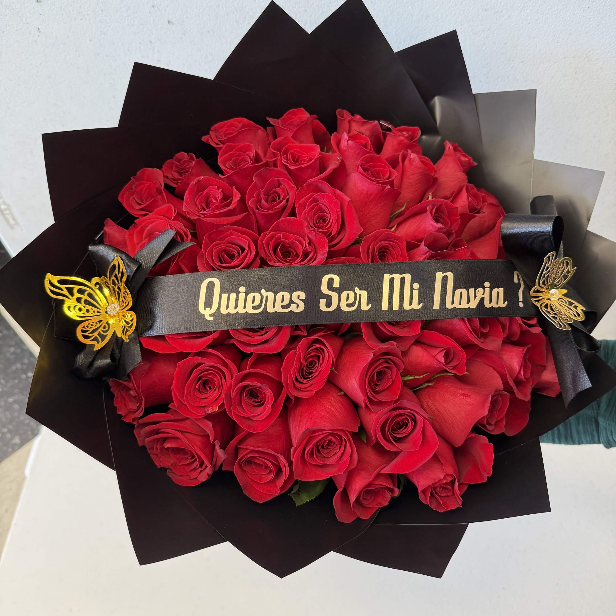 Bouquet of red roses wrapped in black paper with a ribbon