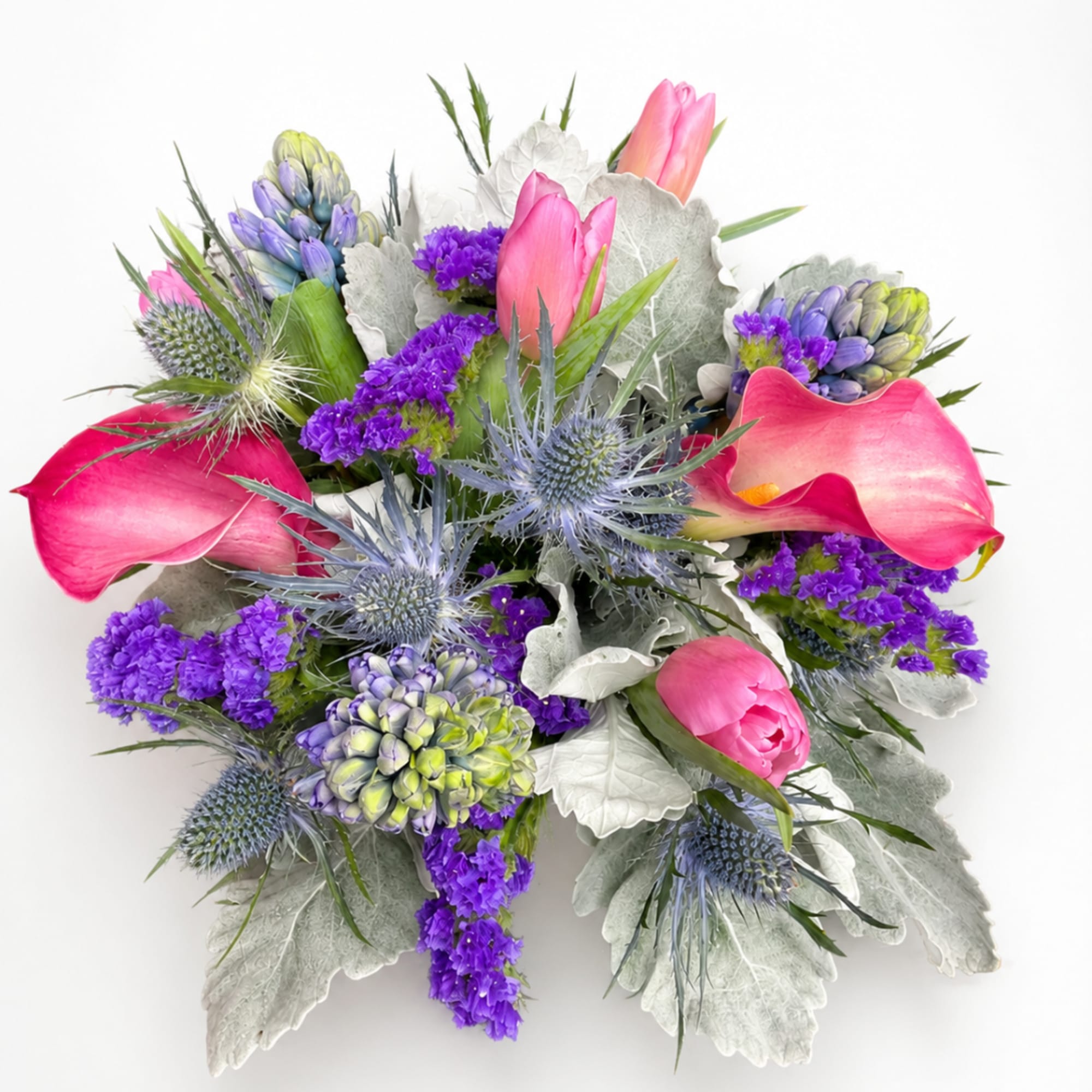 Pink calla lilies and purple flowers with spiky blue thistles