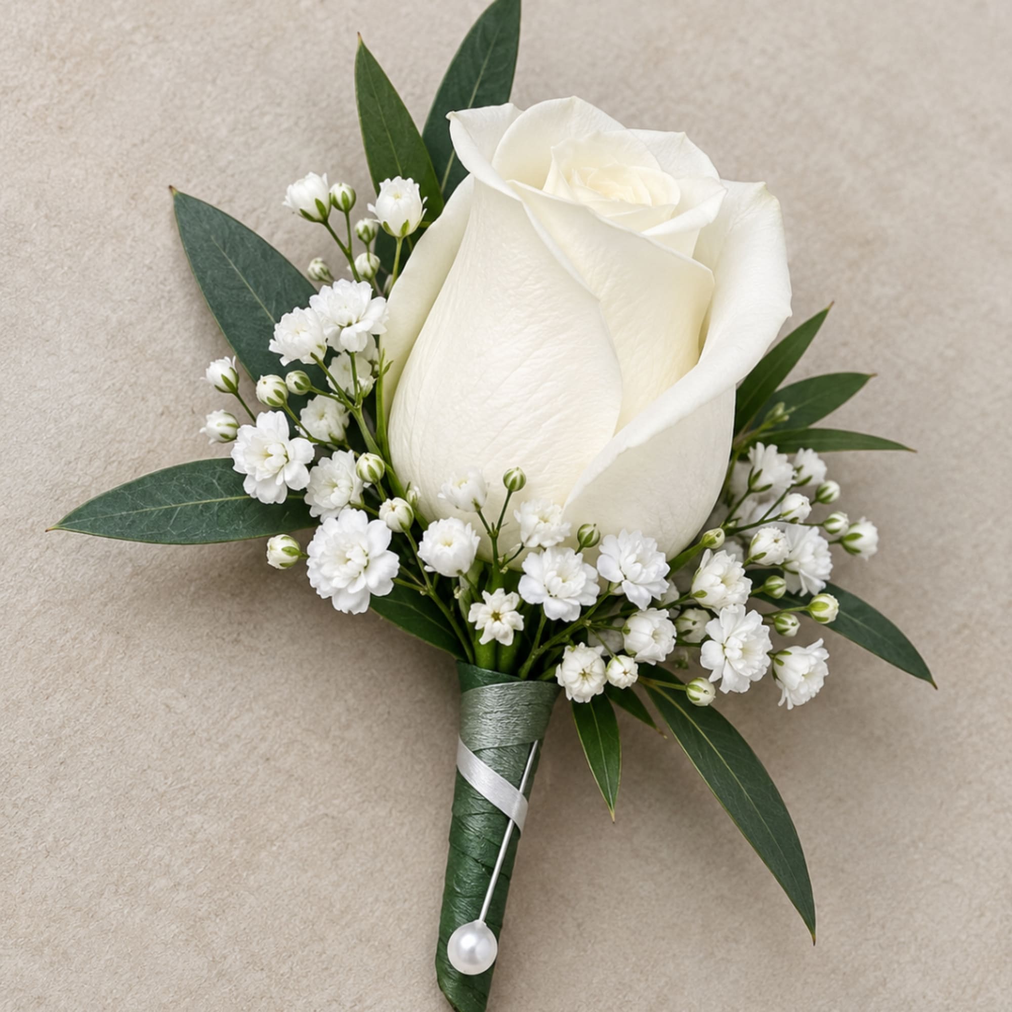 White rose boutonniere with baby's breath and green leaves