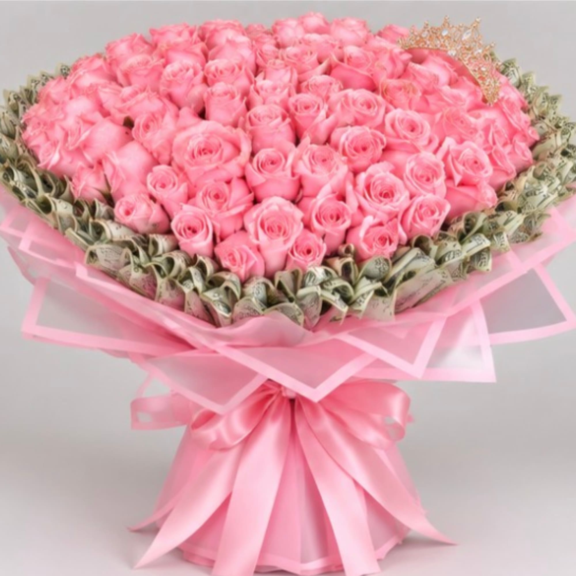 Large bouquet of pink roses wrapped in pink paper with a satin bow