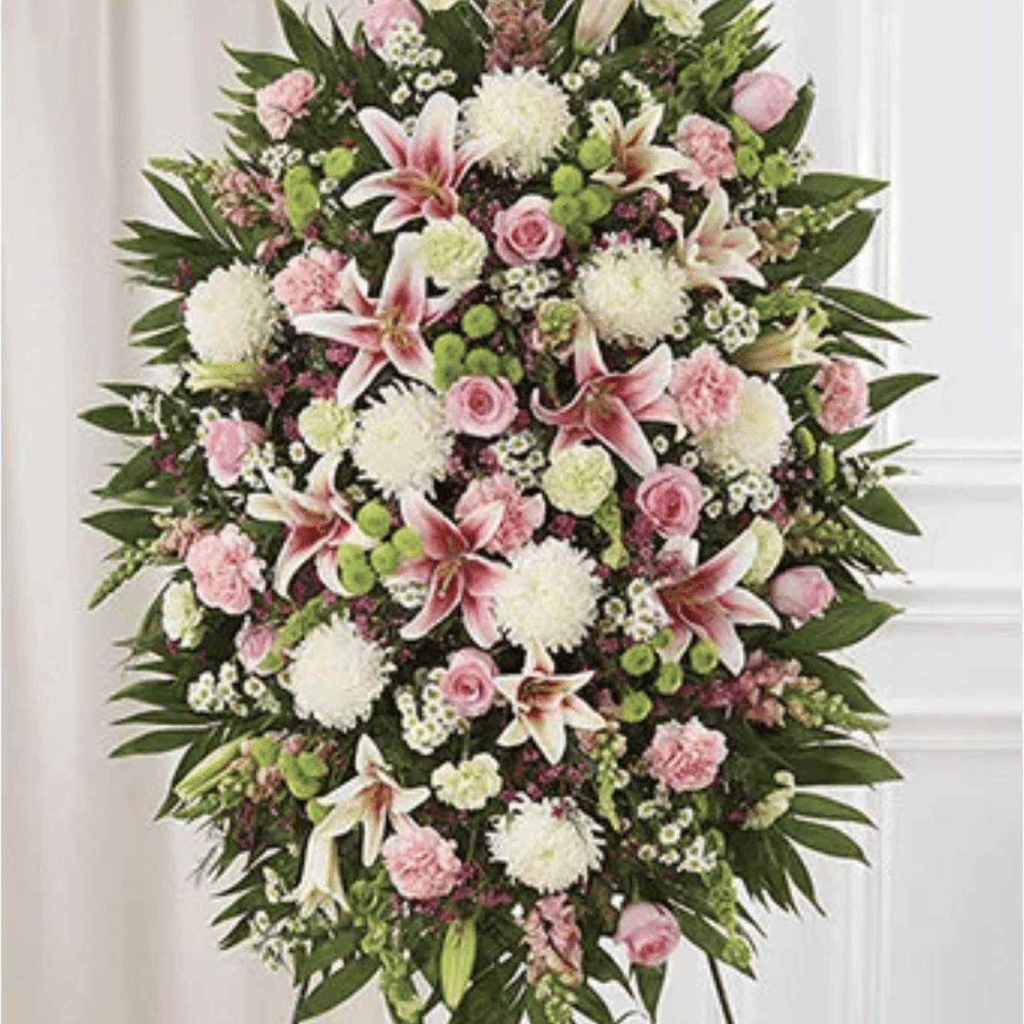 Large pink and white funeral spray on a standing easel