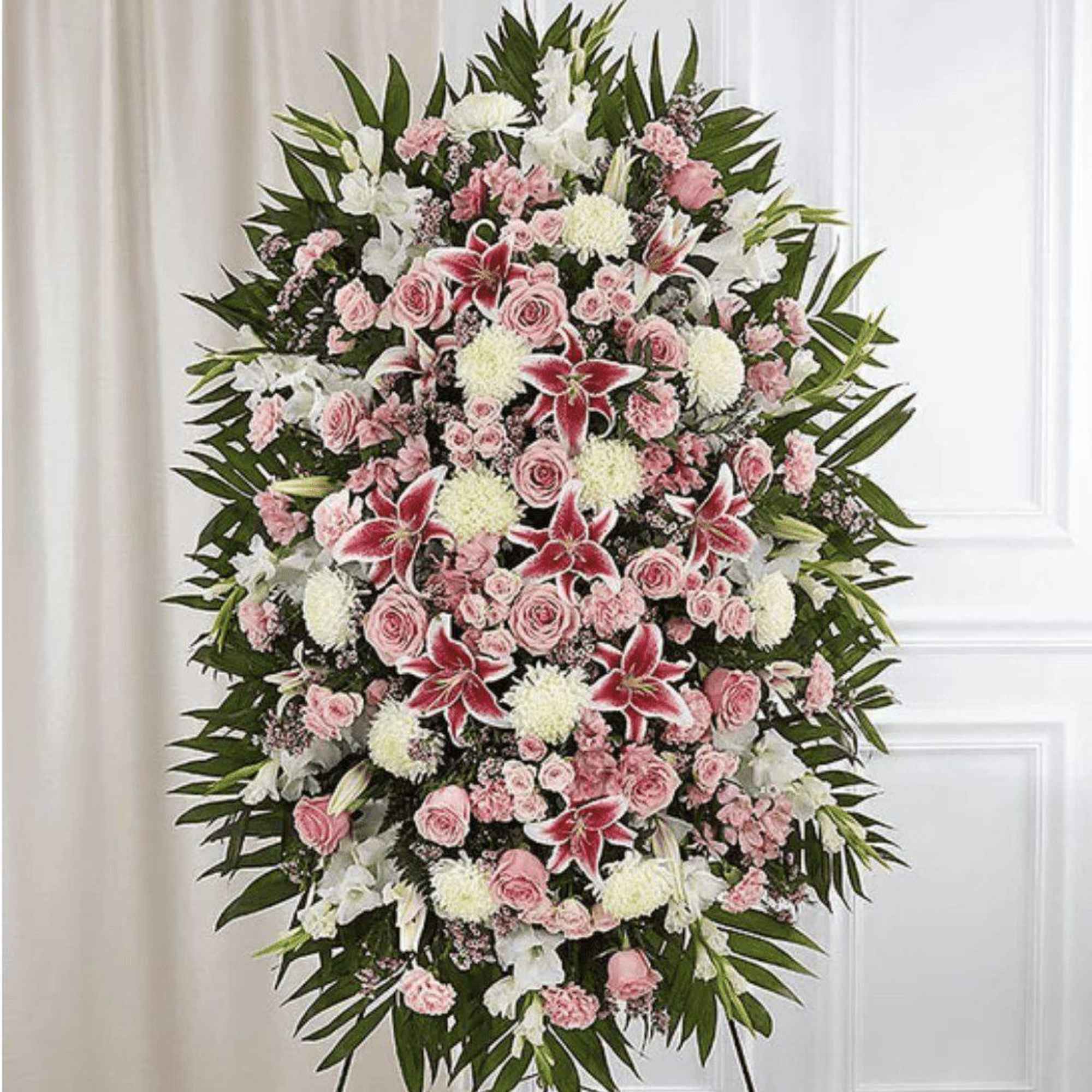 Standing floral spray with pink and white flowers on a wire easel