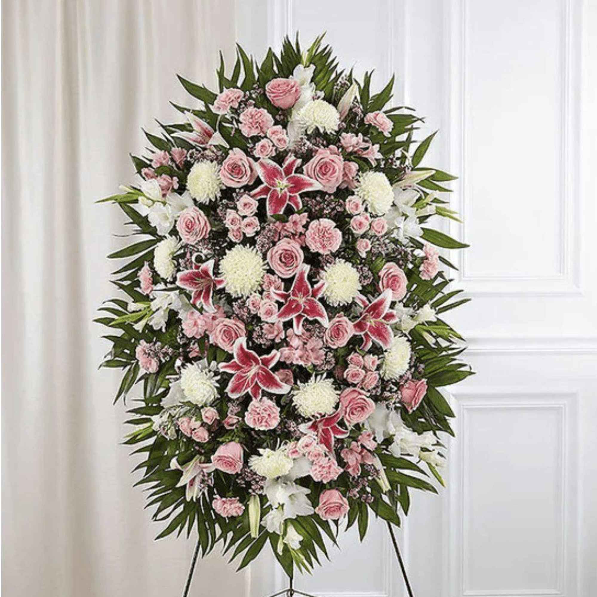 Standing floral spray with pink and white flowers on a metal easel
