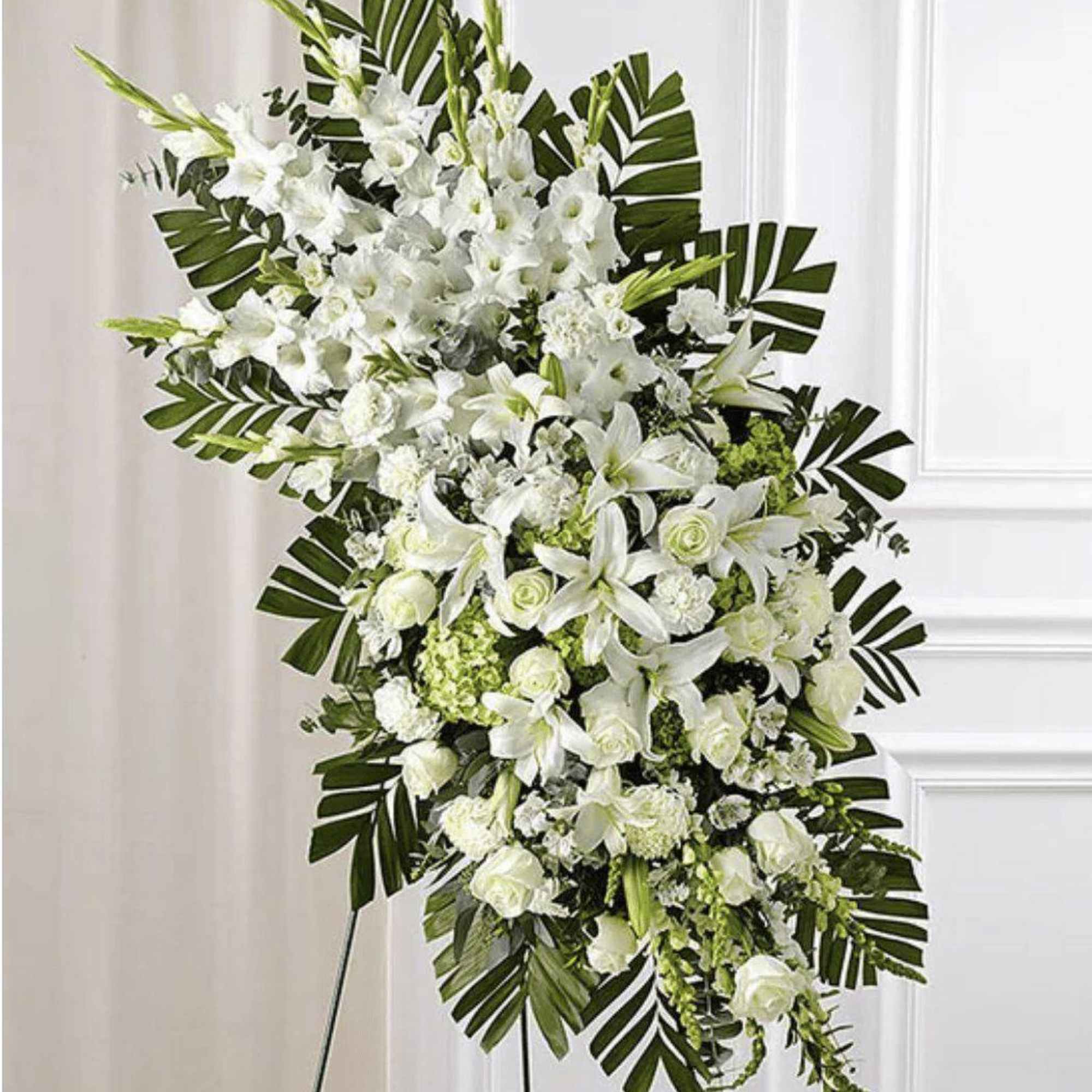 White floral standing spray with lilies and roses on a display easel