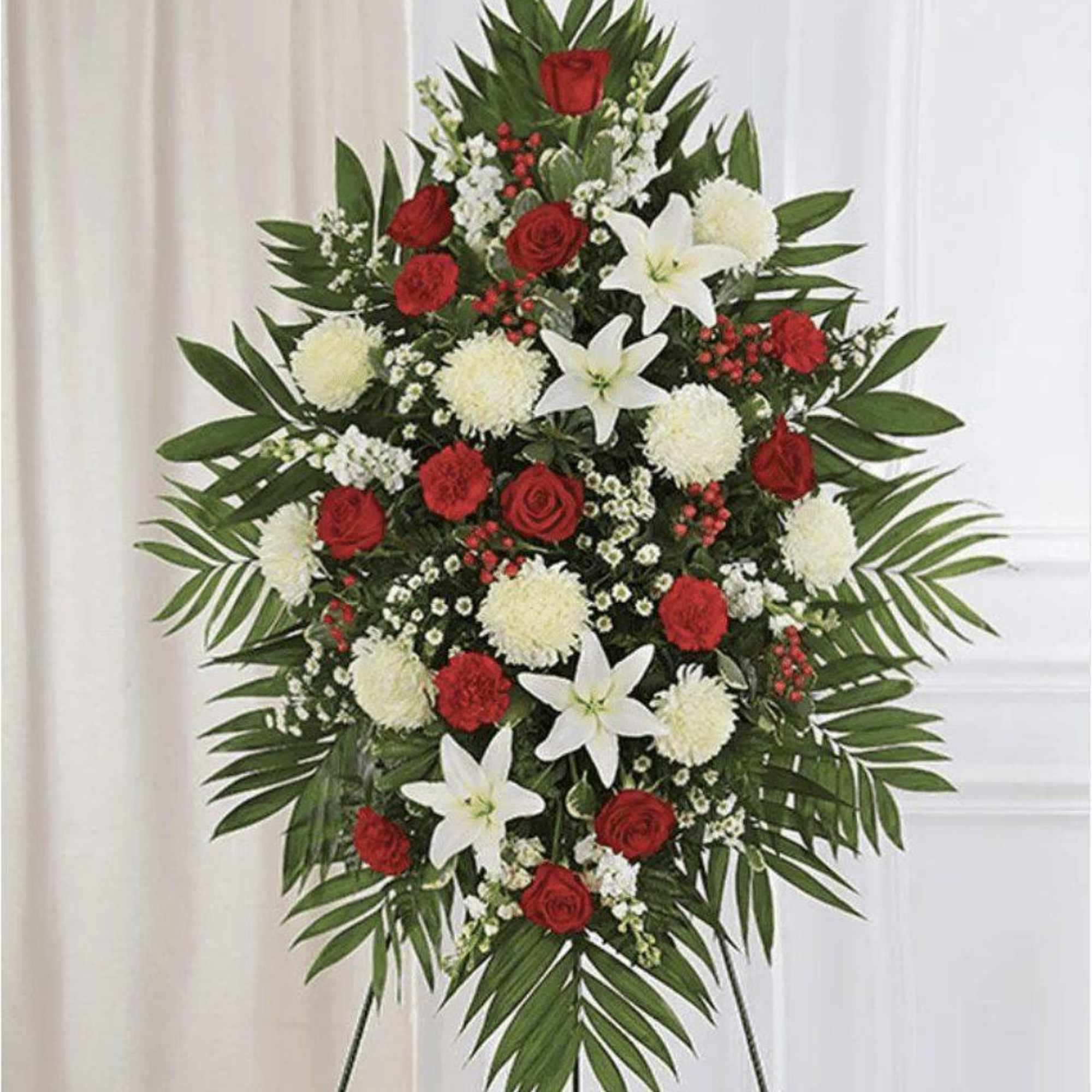 Standing floral spray with red roses, white lilies, and white pompons
