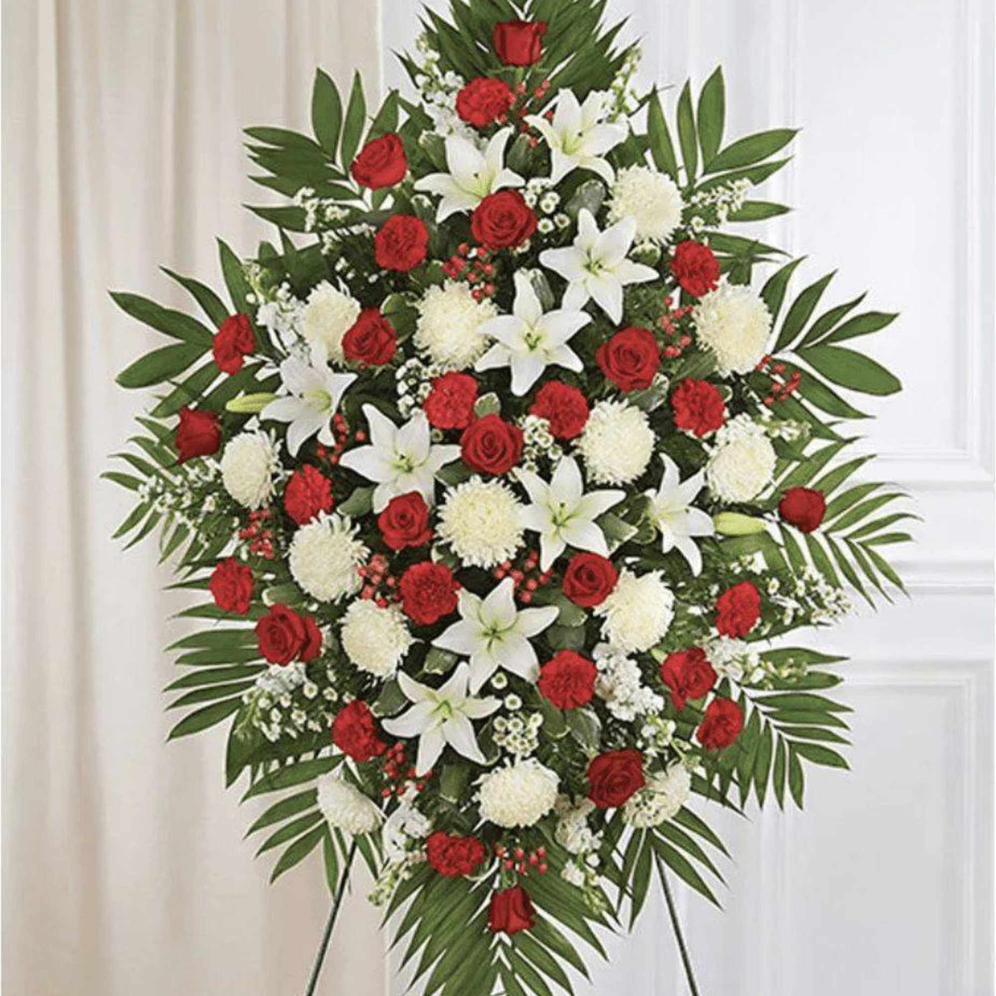 Standing floral spray with red roses, white lilies, and white pompons