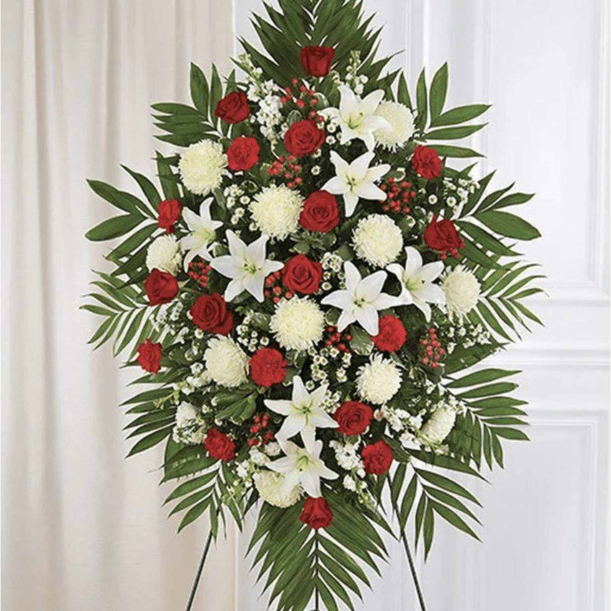 Standing floral spray with red roses, white lilies, and white pompons