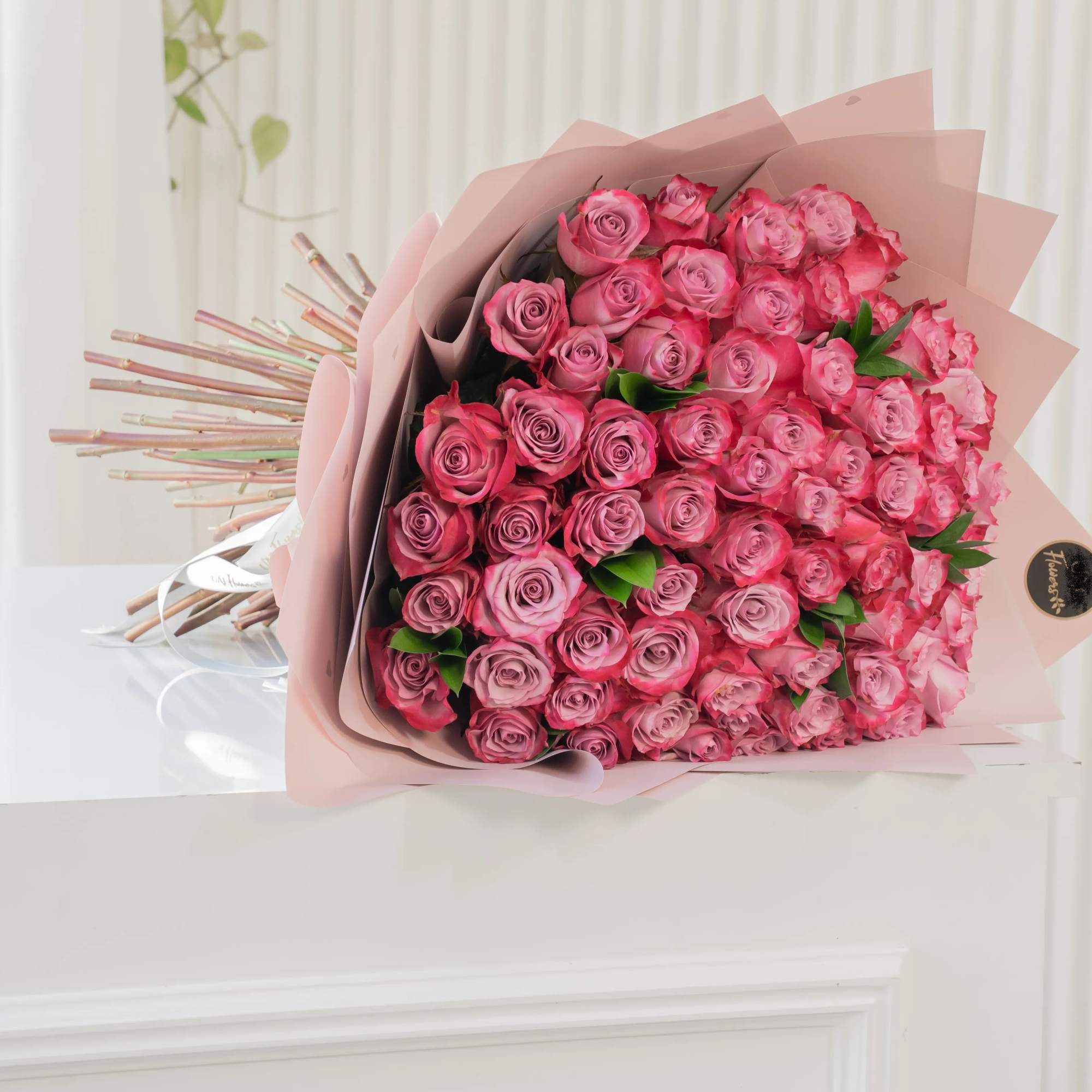 Large bouquet of pink roses wrapped in blush paper