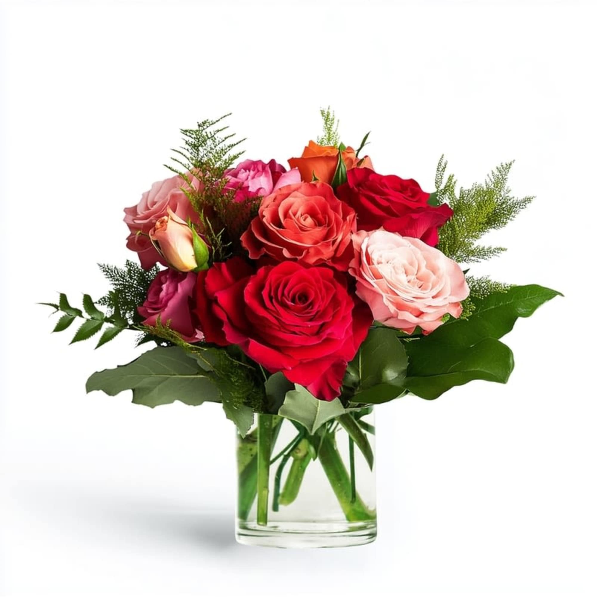 Compact arrangement of red, pink, and peach roses in a clear glass vase.