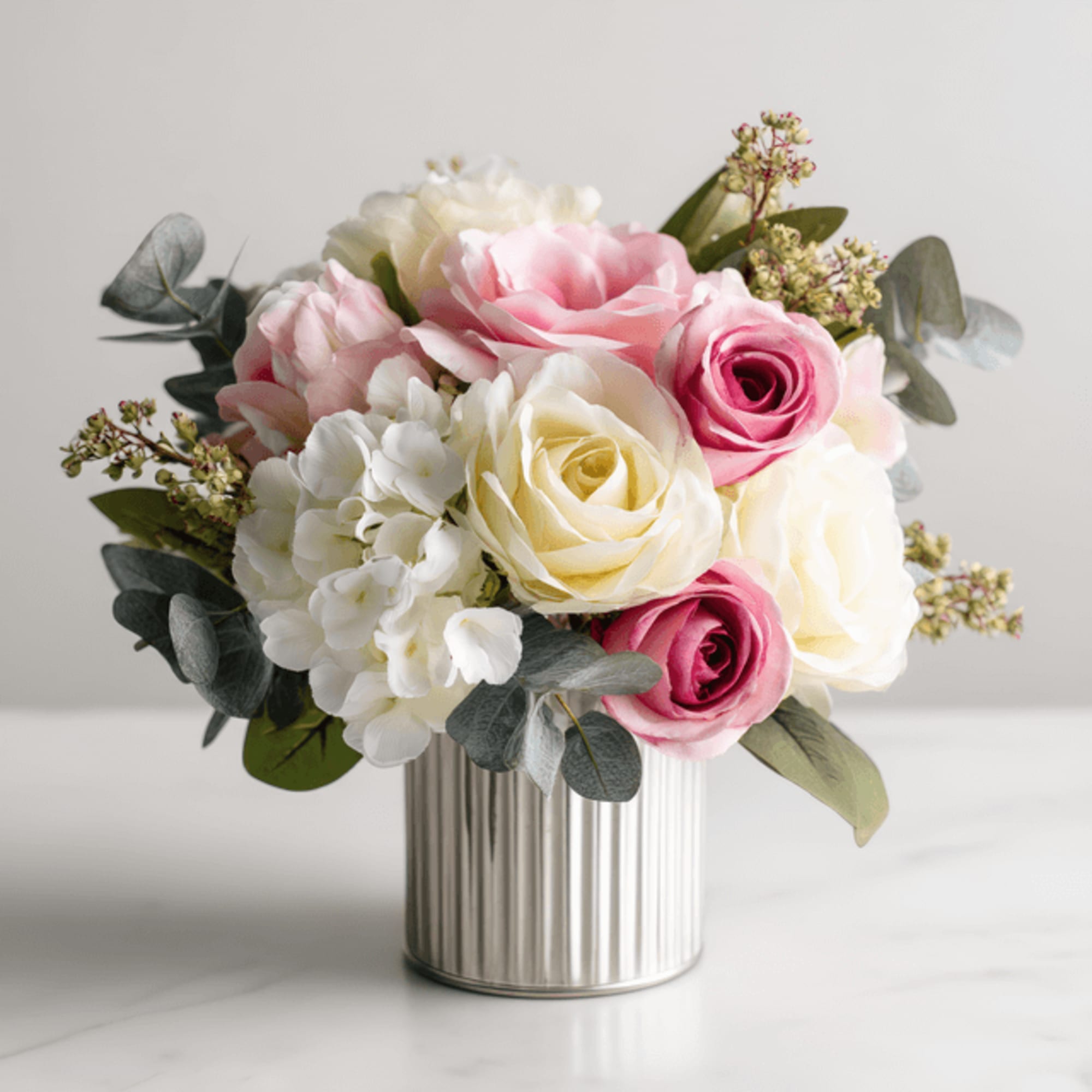 Pink and white roses arranged in a ribbed metal vase, photo 2 of 2
