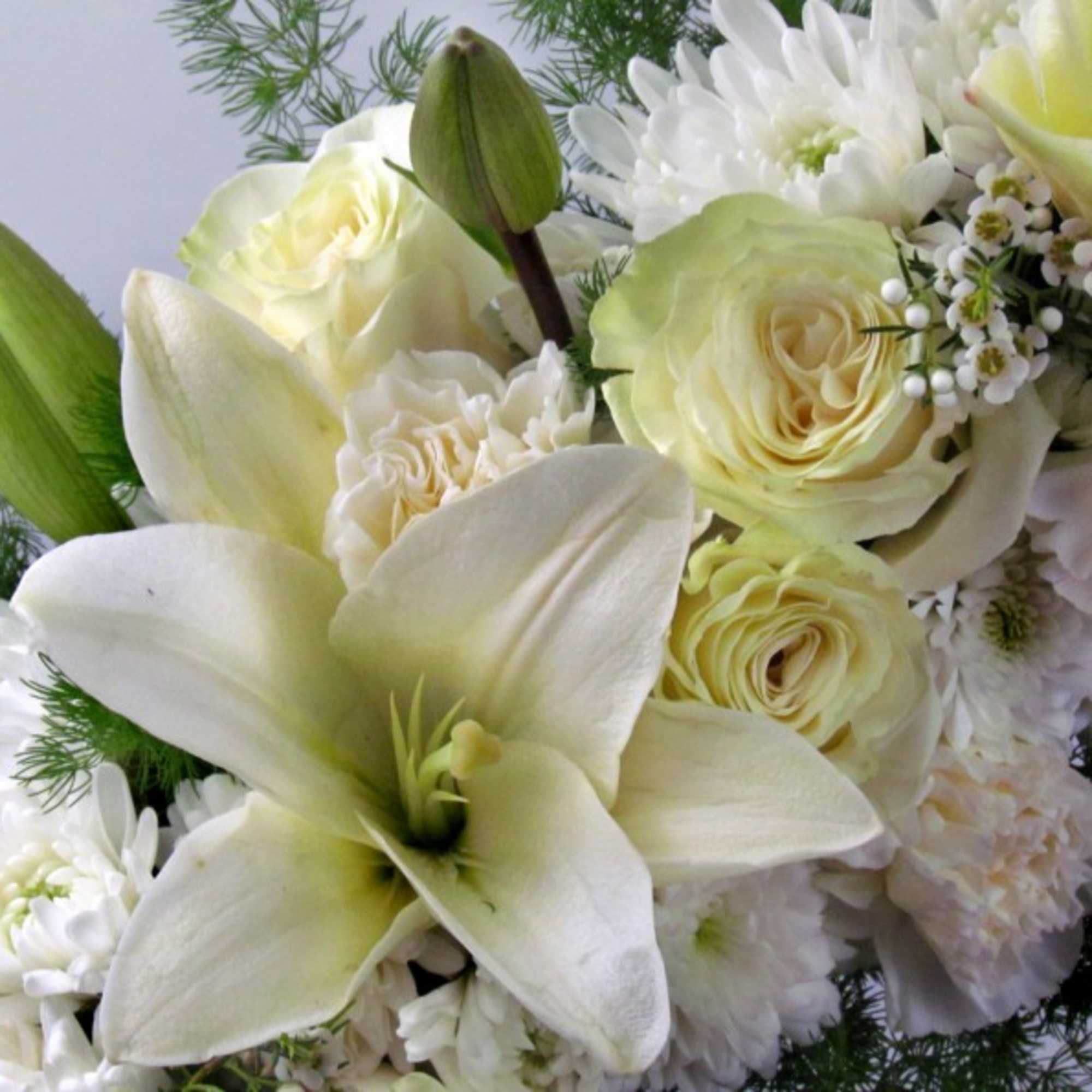 White lilies and pale yellow roses in a bouquet