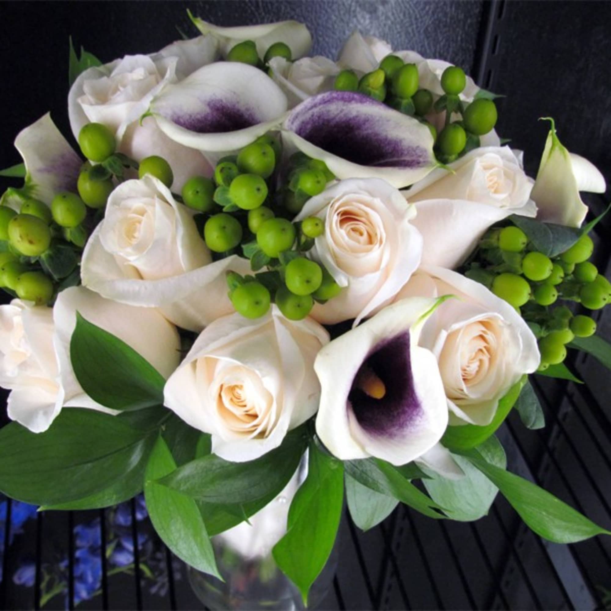 Bouquet of white roses and calla lilies with green berries