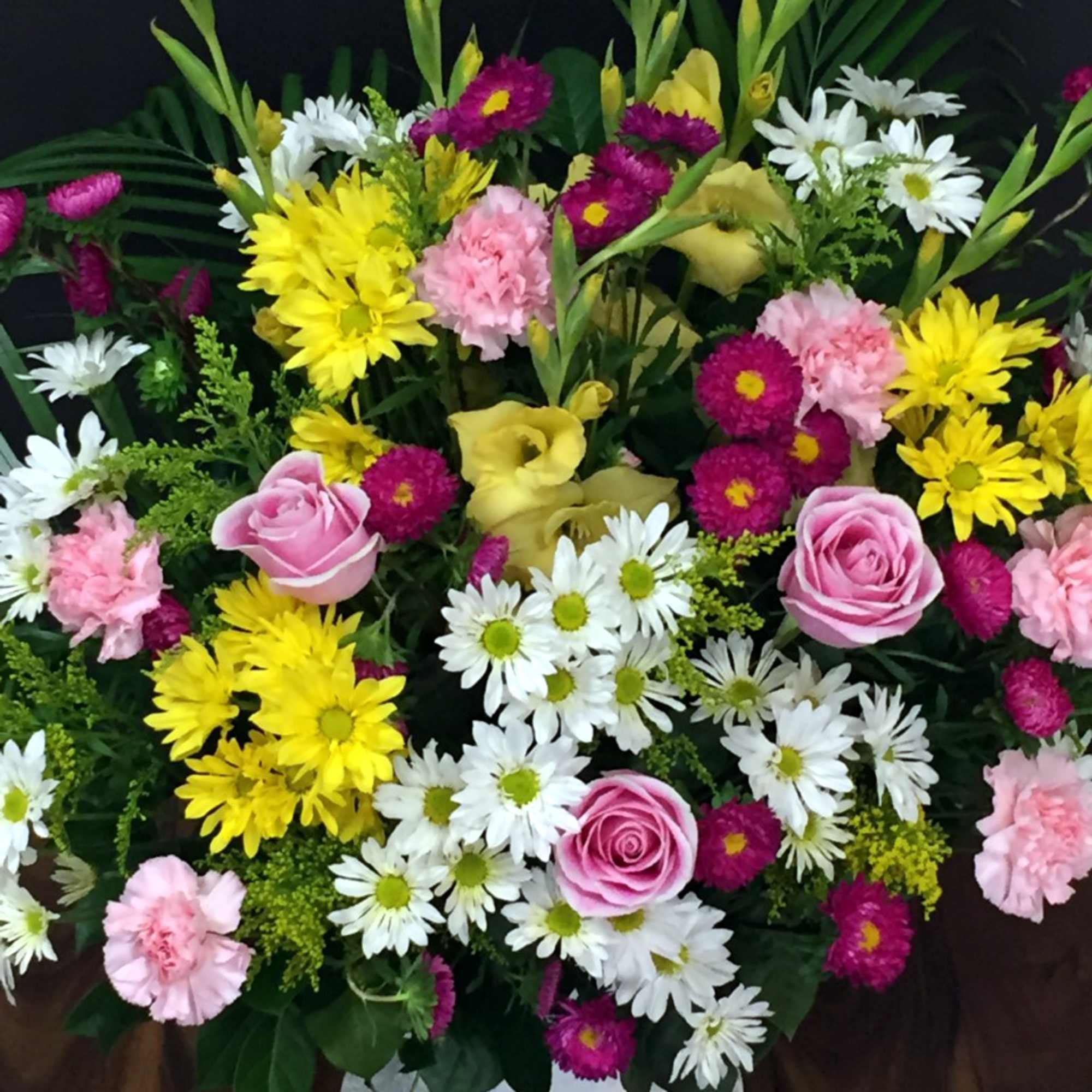 Mixed bouquet with pink roses, yellow daisies, white daisies, and carnations