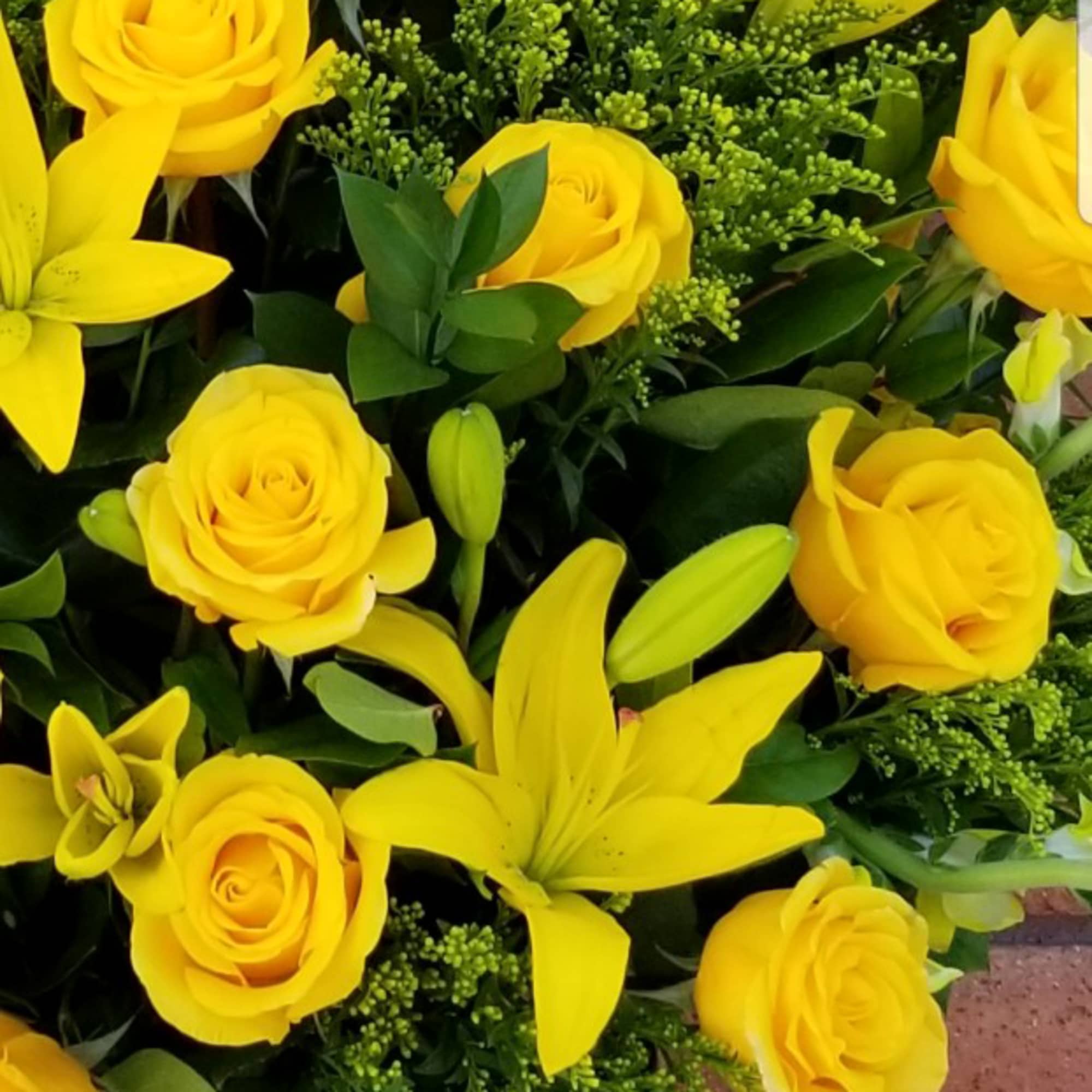 Yellow roses and lilies in a dense bouquet