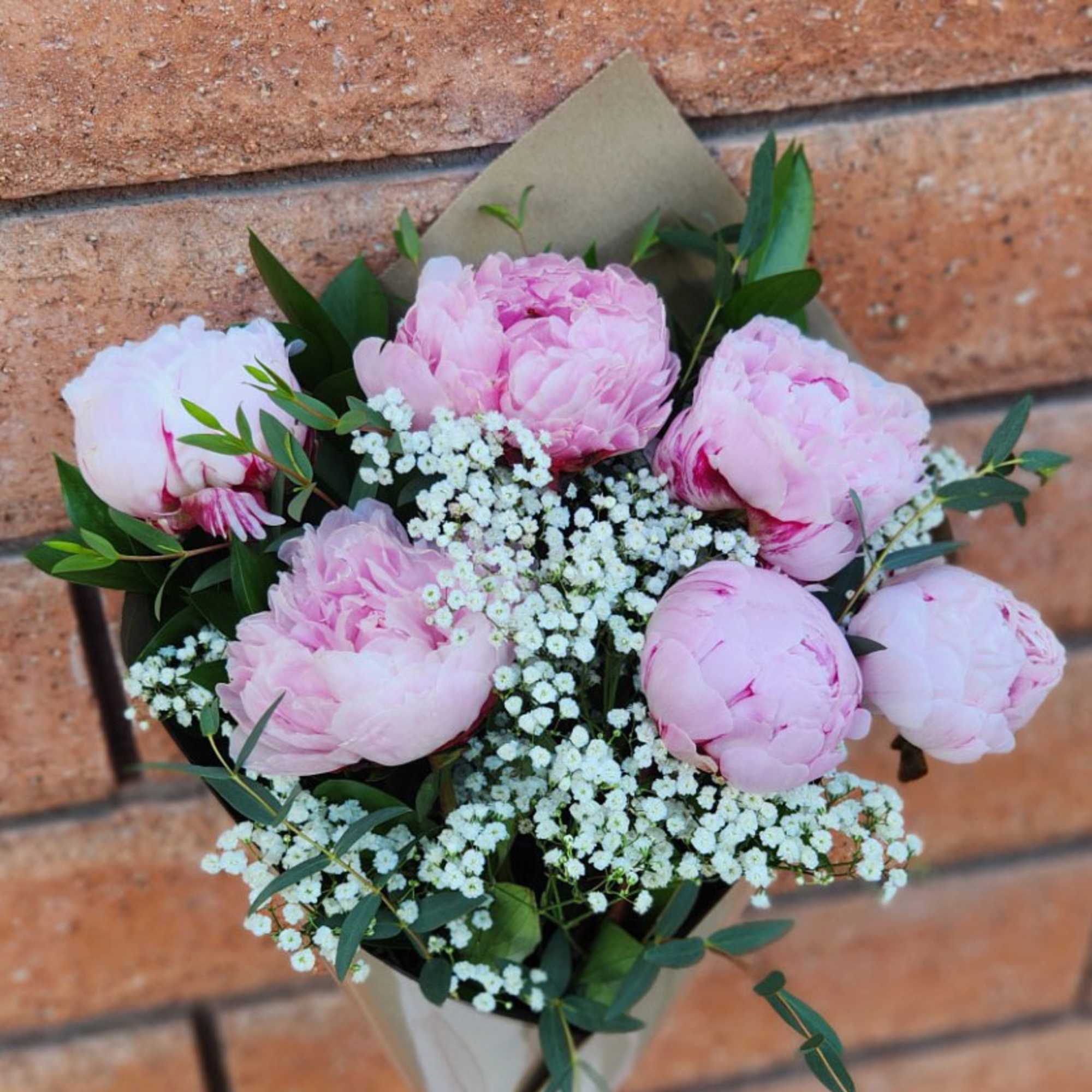 Bouquet of pink peonies with white filler flowers