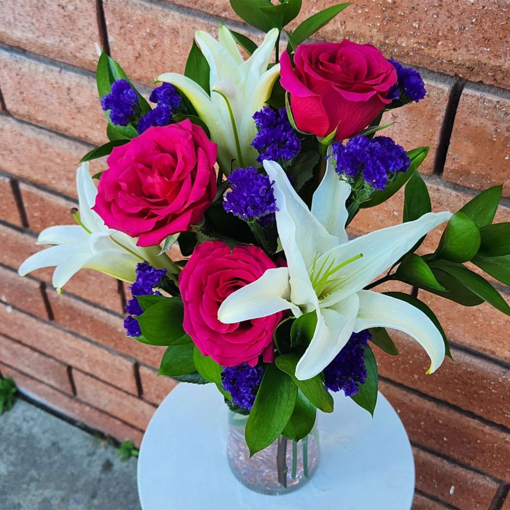 Pink roses and white lilies in a clear glass vase, photo 2 of 3