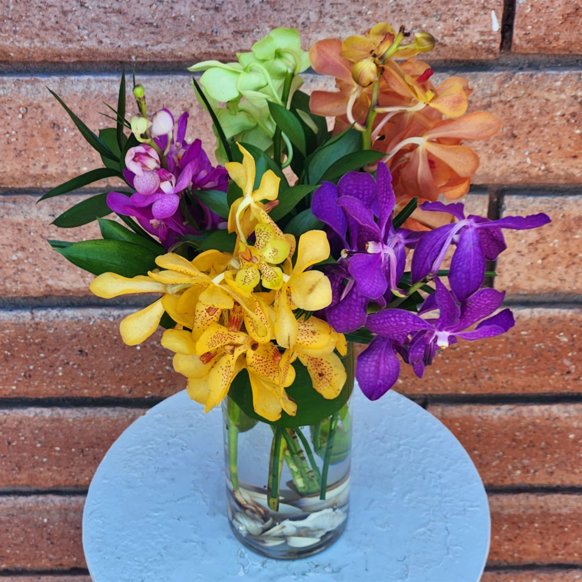 Colorful orchid bouquet in a clear glass vase