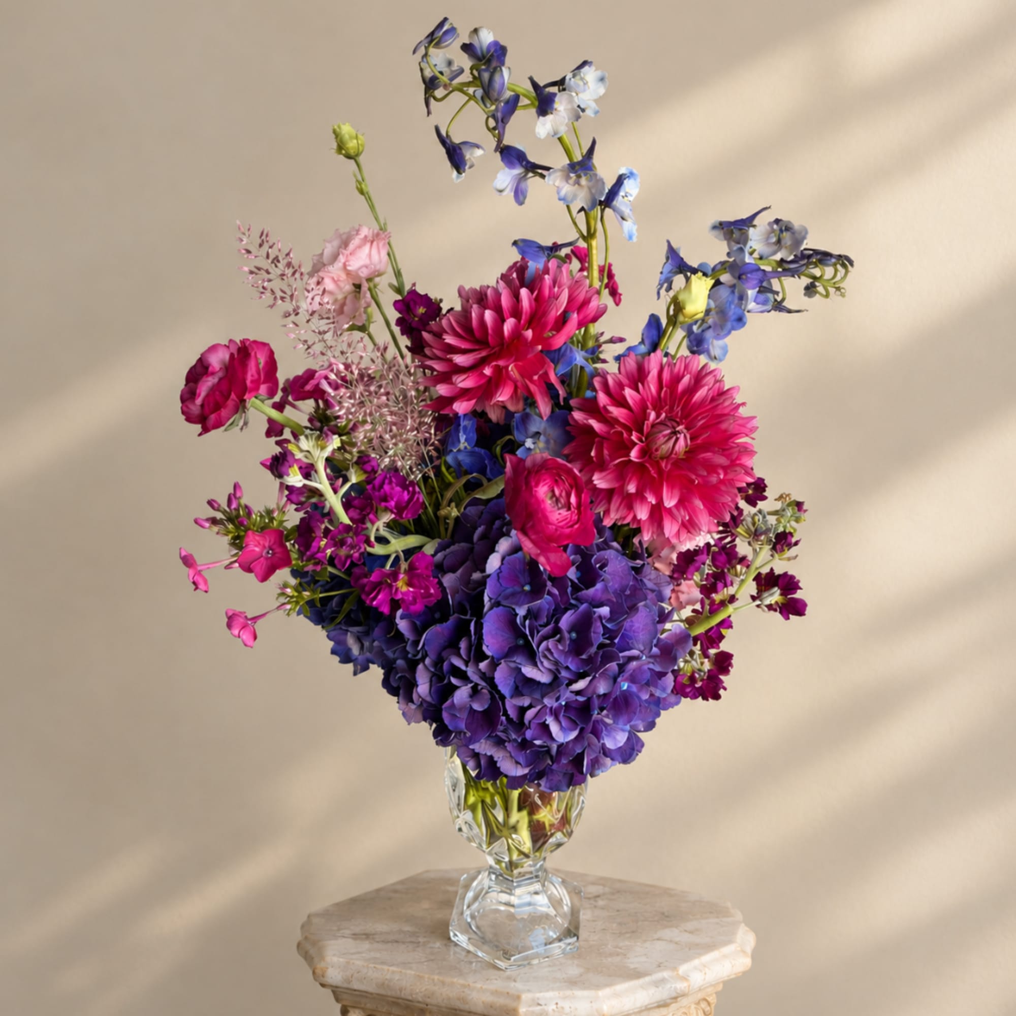Colorful bouquet of pink, purple, and blue flowers in a clear glass vase