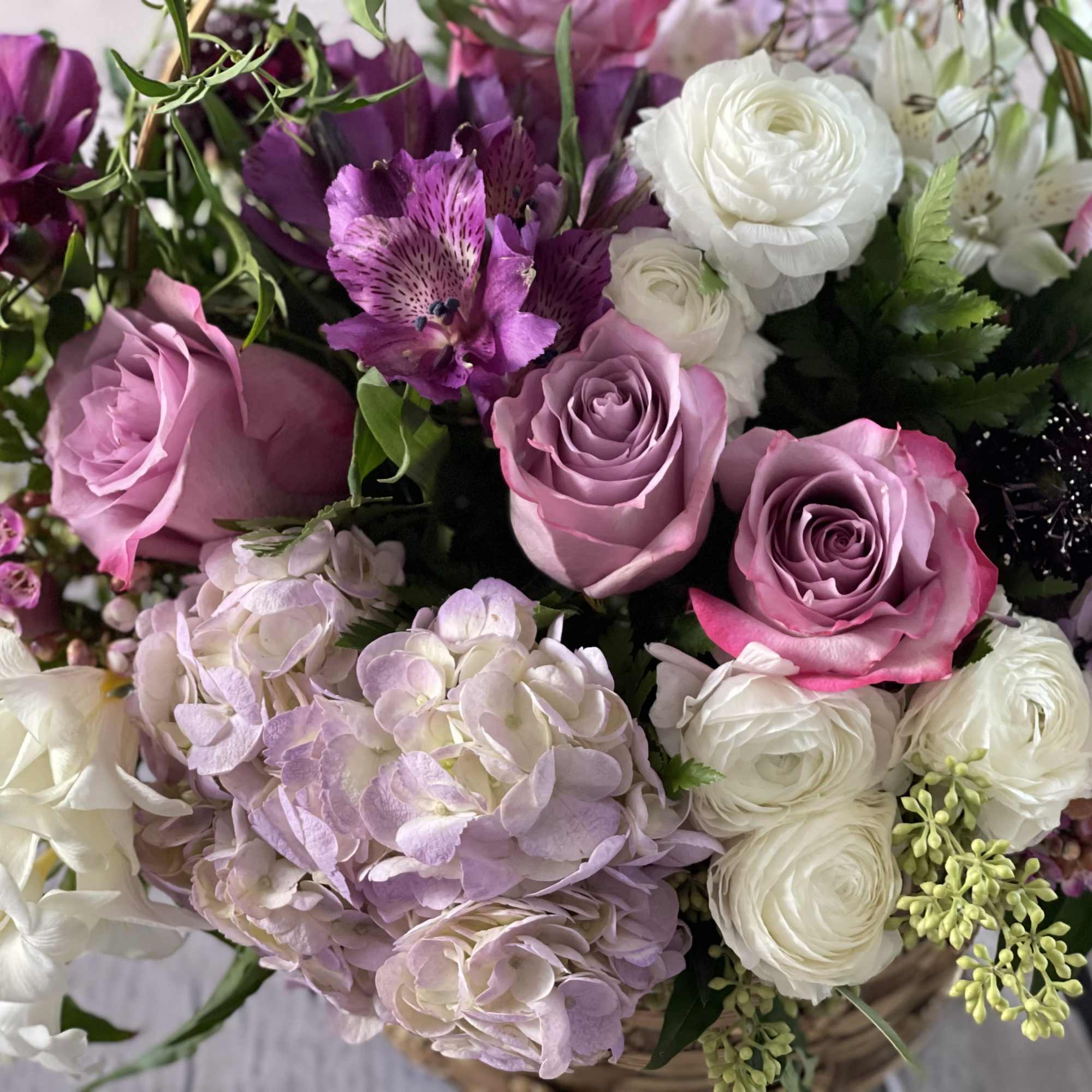 Bouquet of pink, purple, and white flowers in a basket