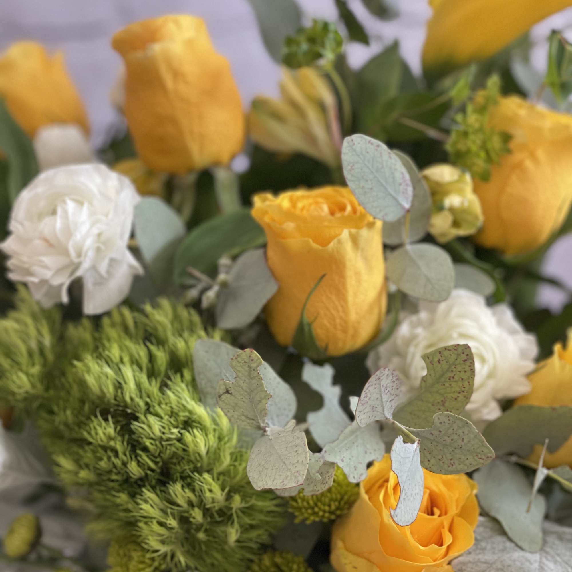 Bouquet of yellow and white roses with greenery