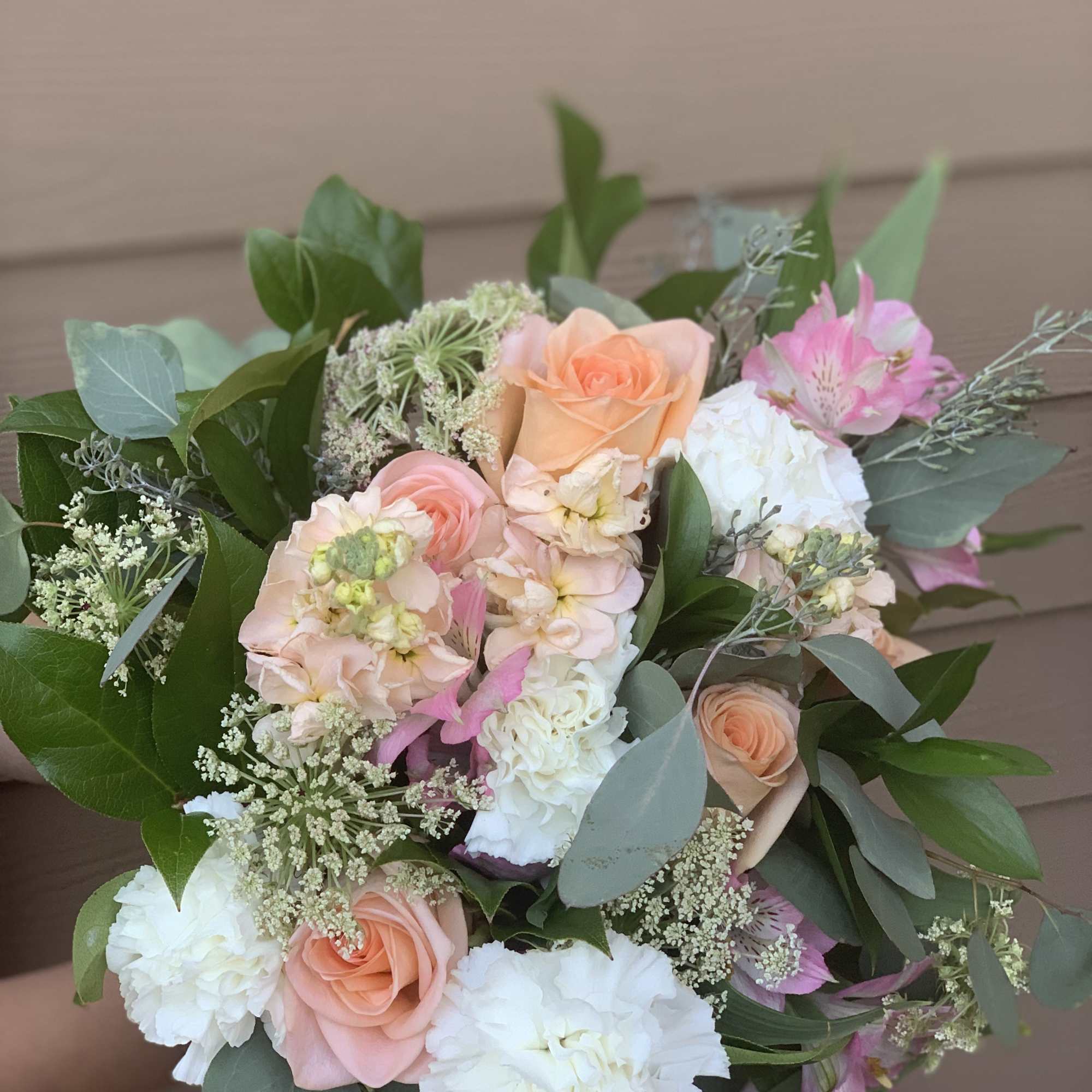 Bouquet of peach, pink, and white flowers with greenery