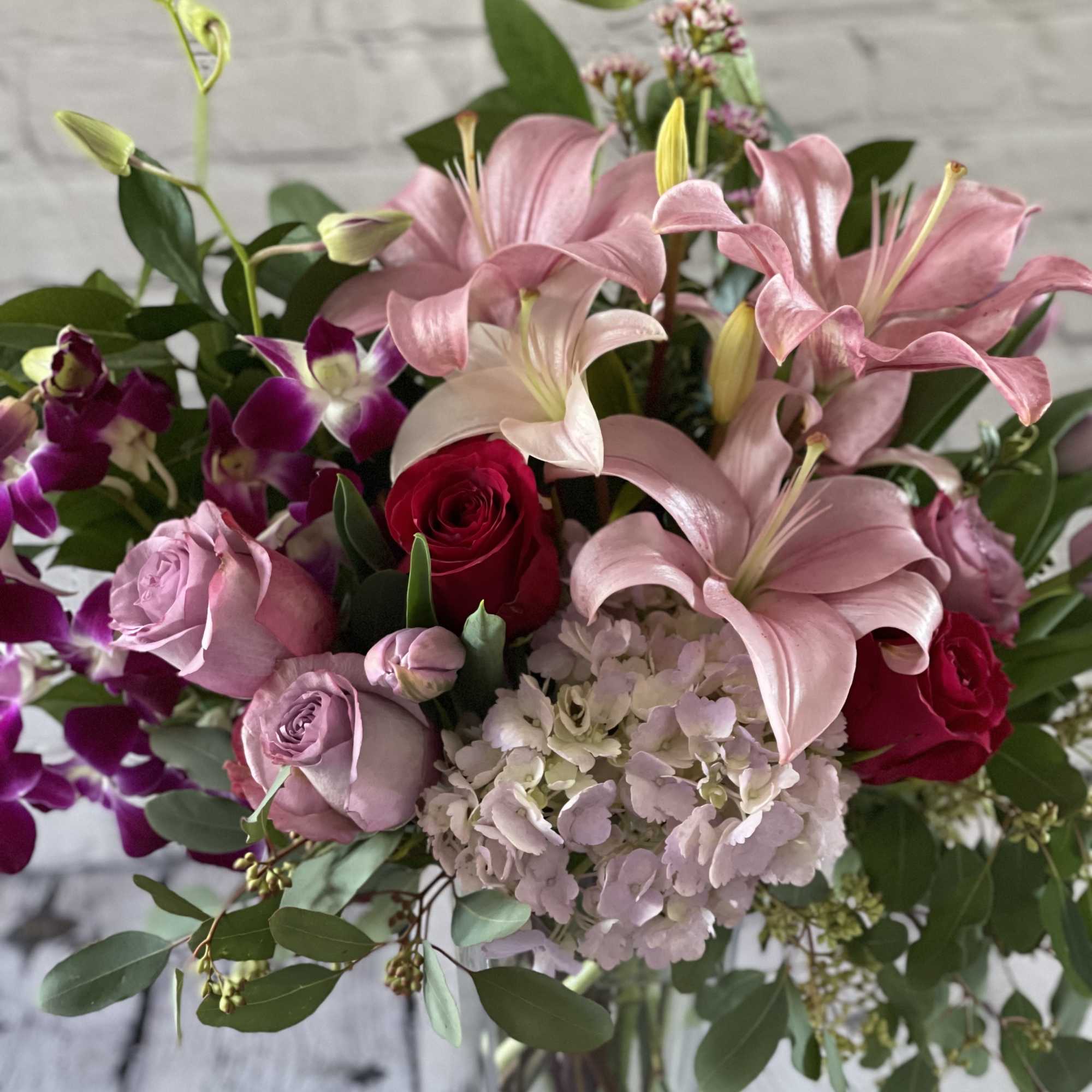 Bouquet of pink lilies, roses, hydrangea, and purple orchids