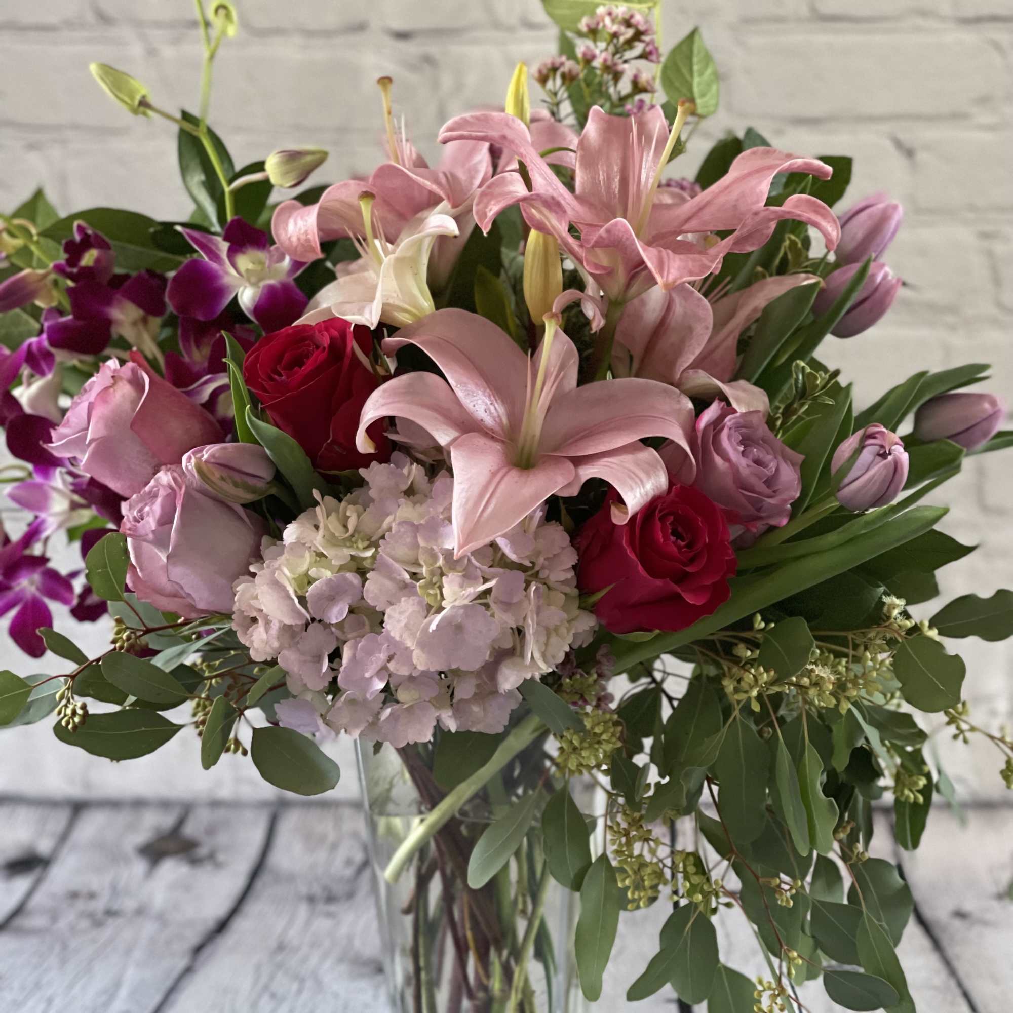 Pink lilies and roses in a clear glass vase