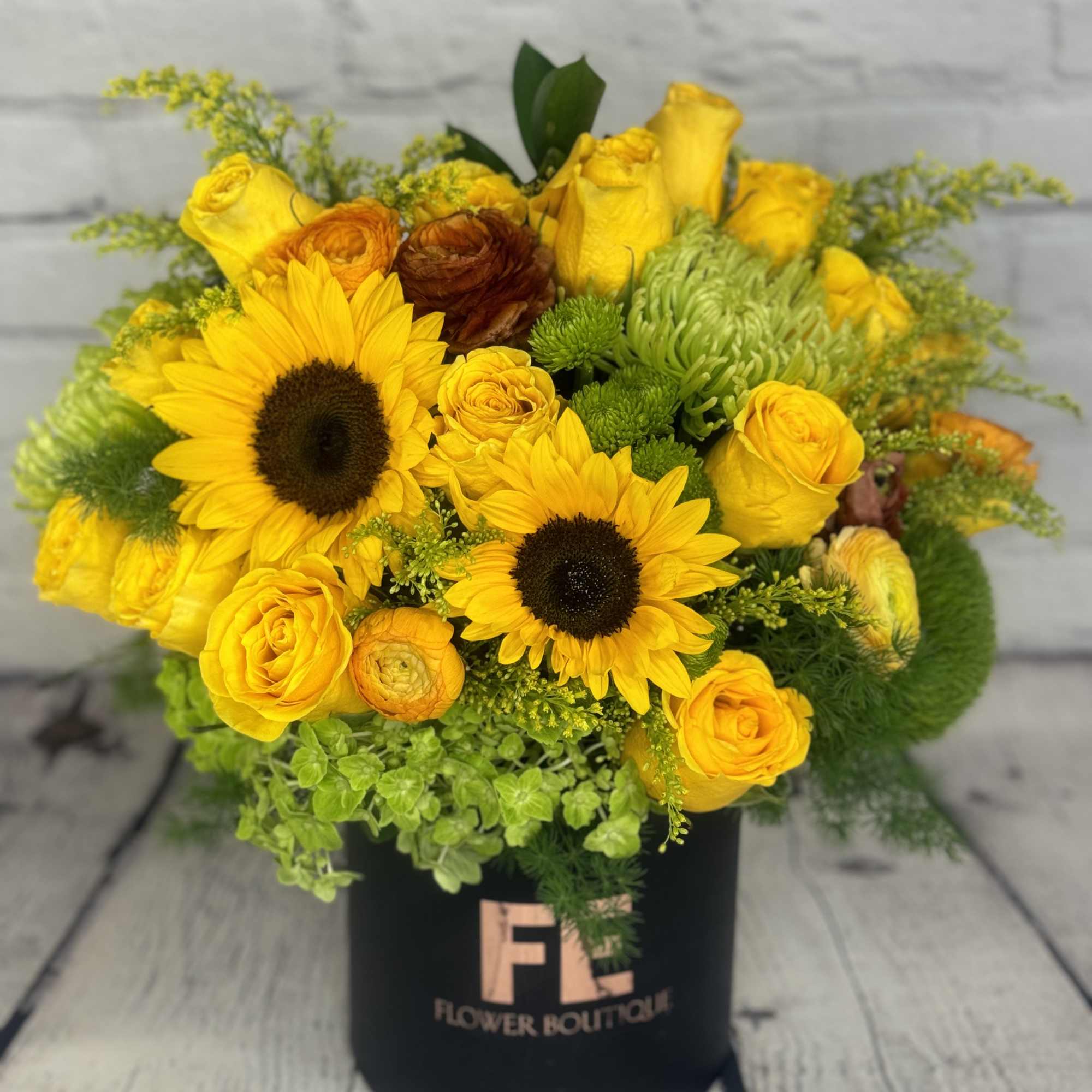 Yellow bouquet with sunflowers and roses in a black box