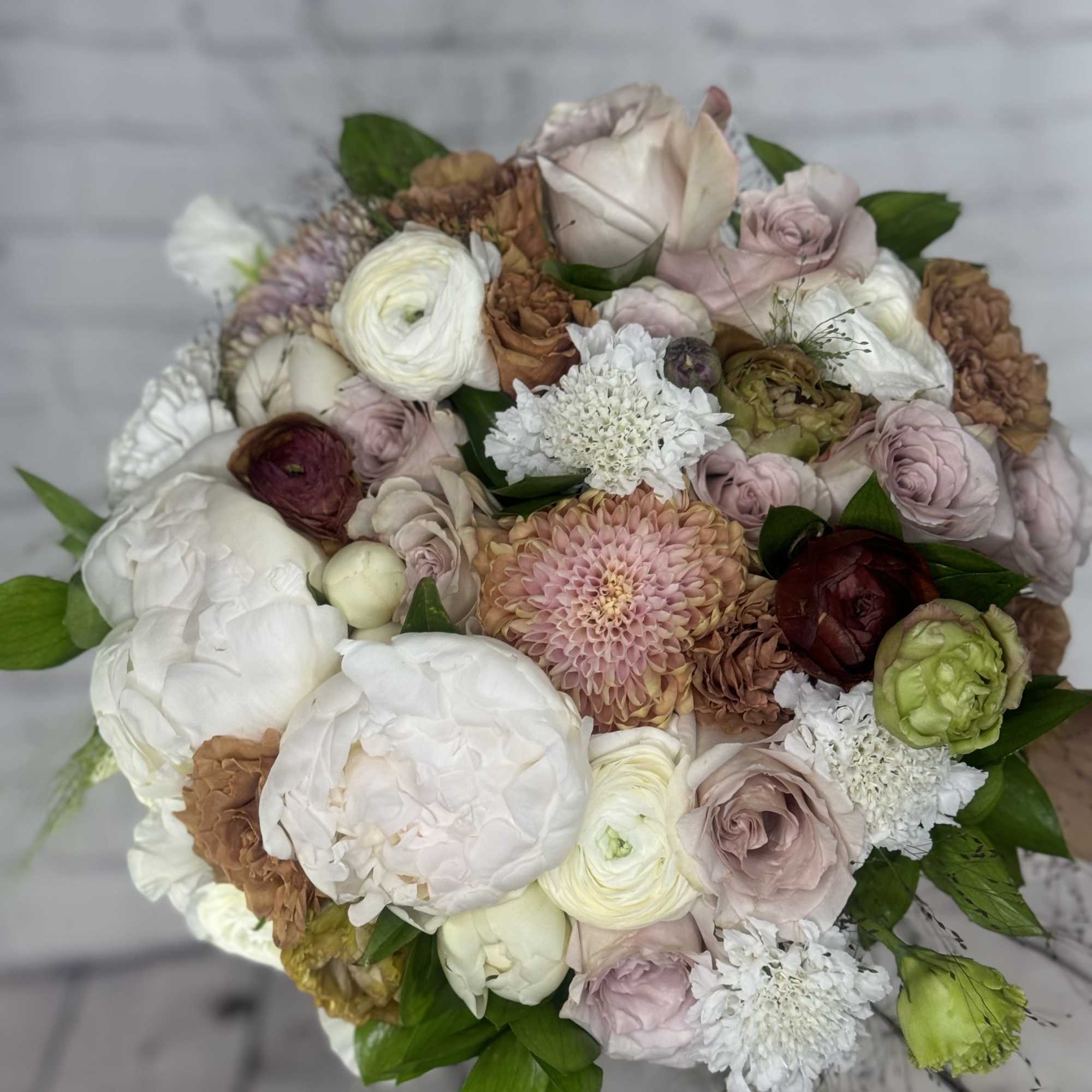 Round bouquet of blush, white, and brown flowers