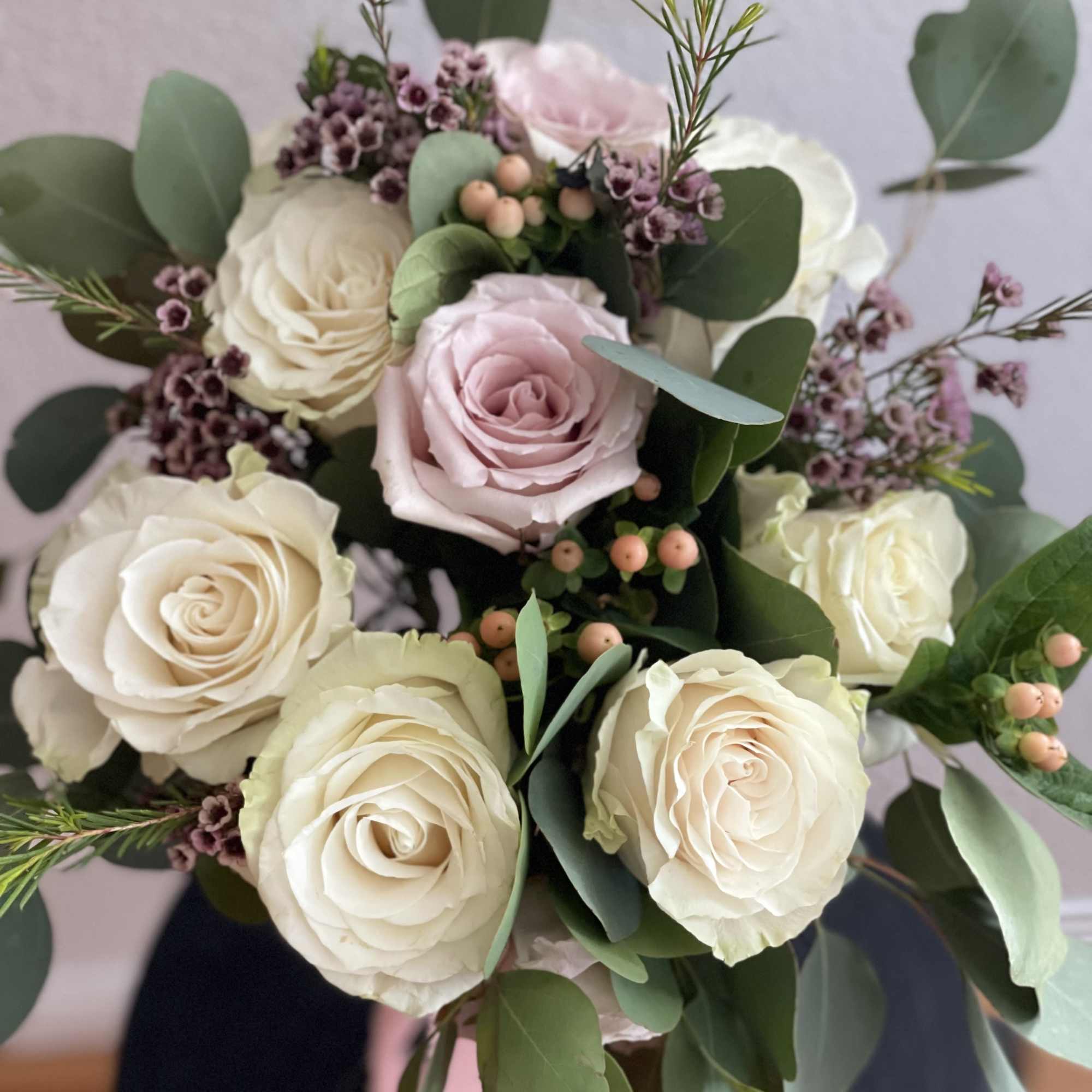 Bouquet of cream and blush roses with eucalyptus and small purple filler flowers, photo 2 of 2