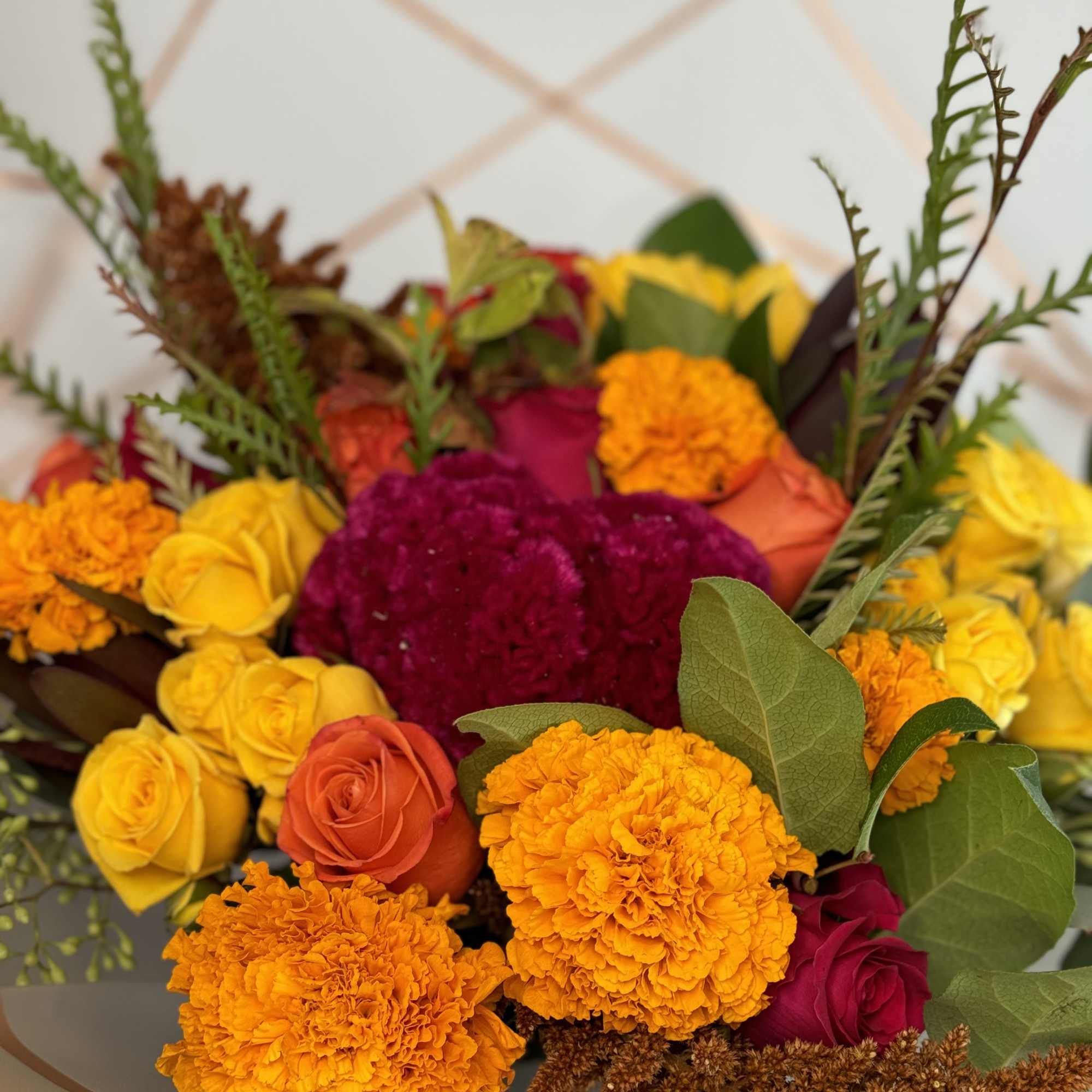 Bouquet of yellow, orange, and magenta roses with marigolds
