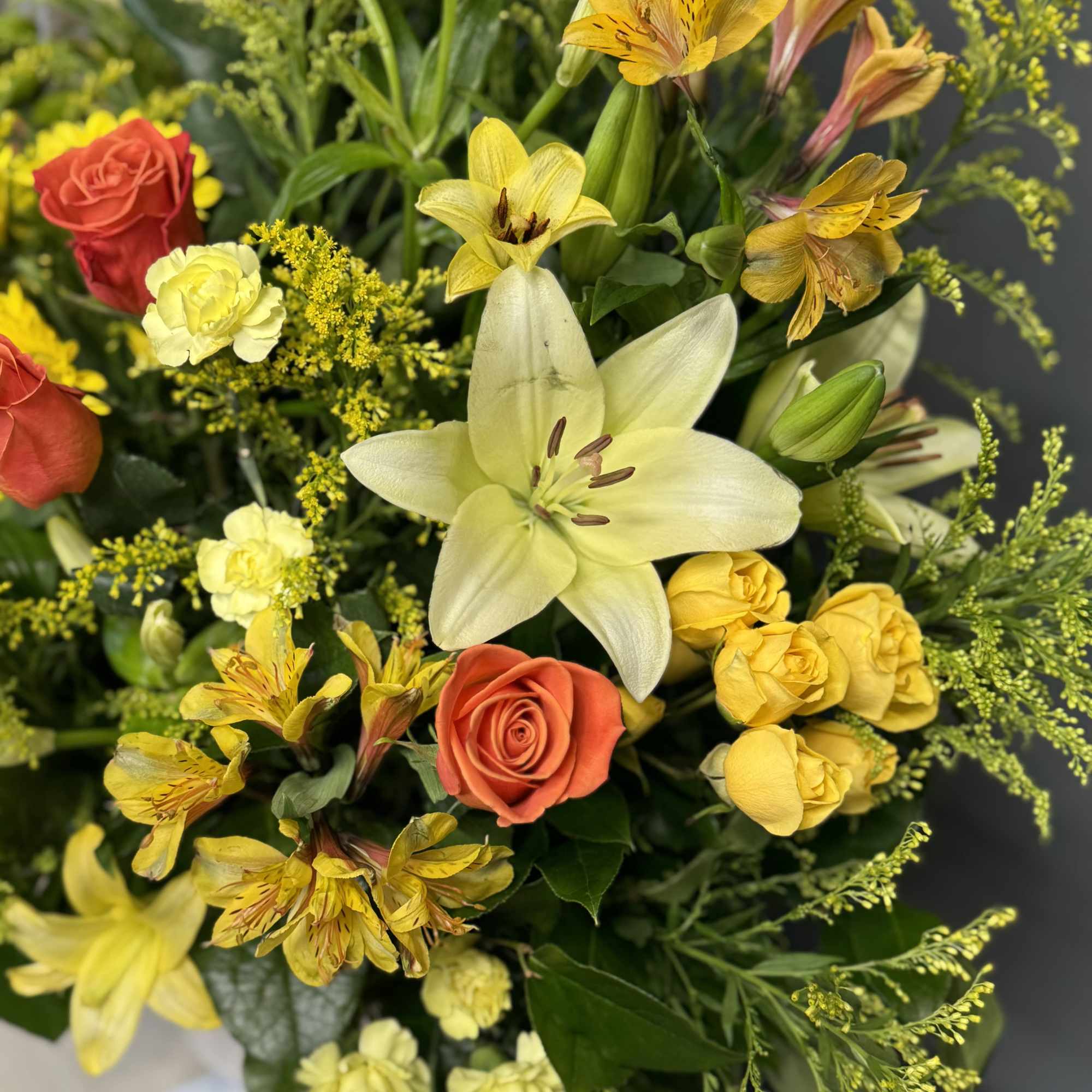 Bouquet of yellow lilies and orange roses with yellow filler flowers