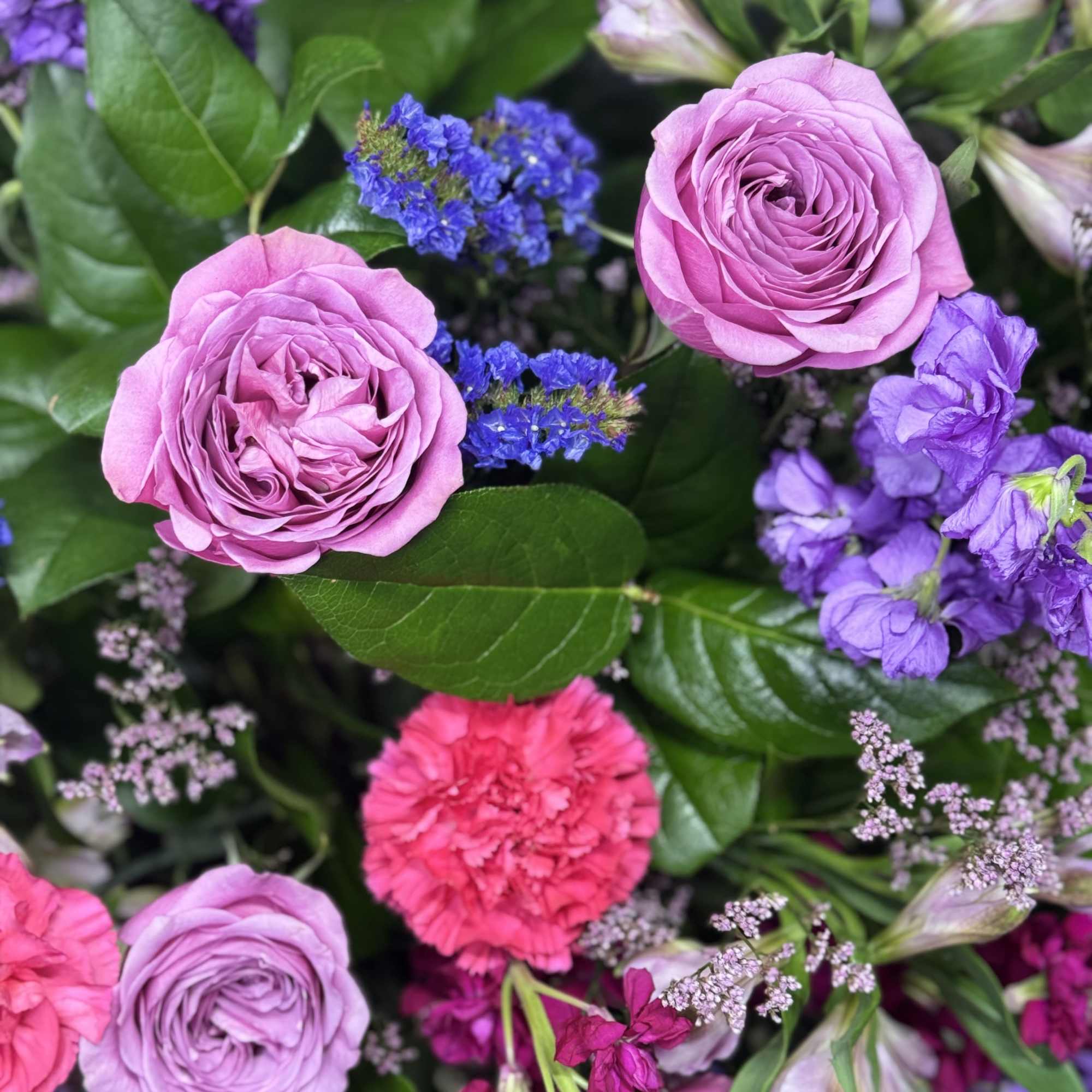 Pink roses and purple flowers in a mixed bouquet
