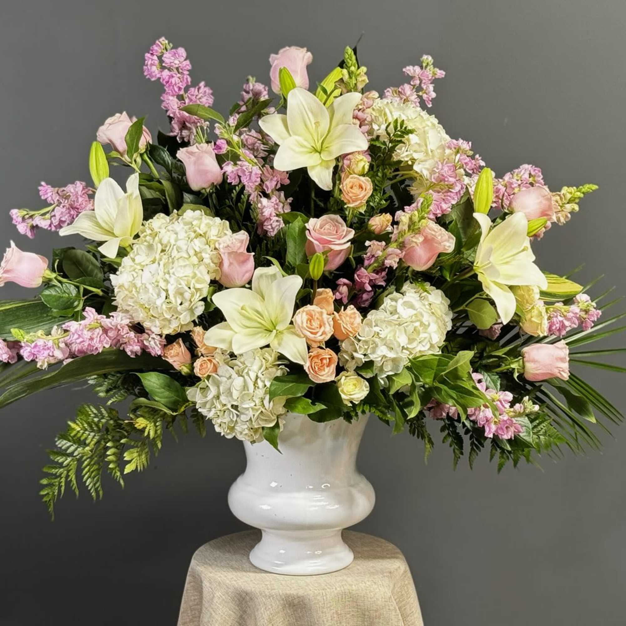 Pink and white floral arrangement in a white vase