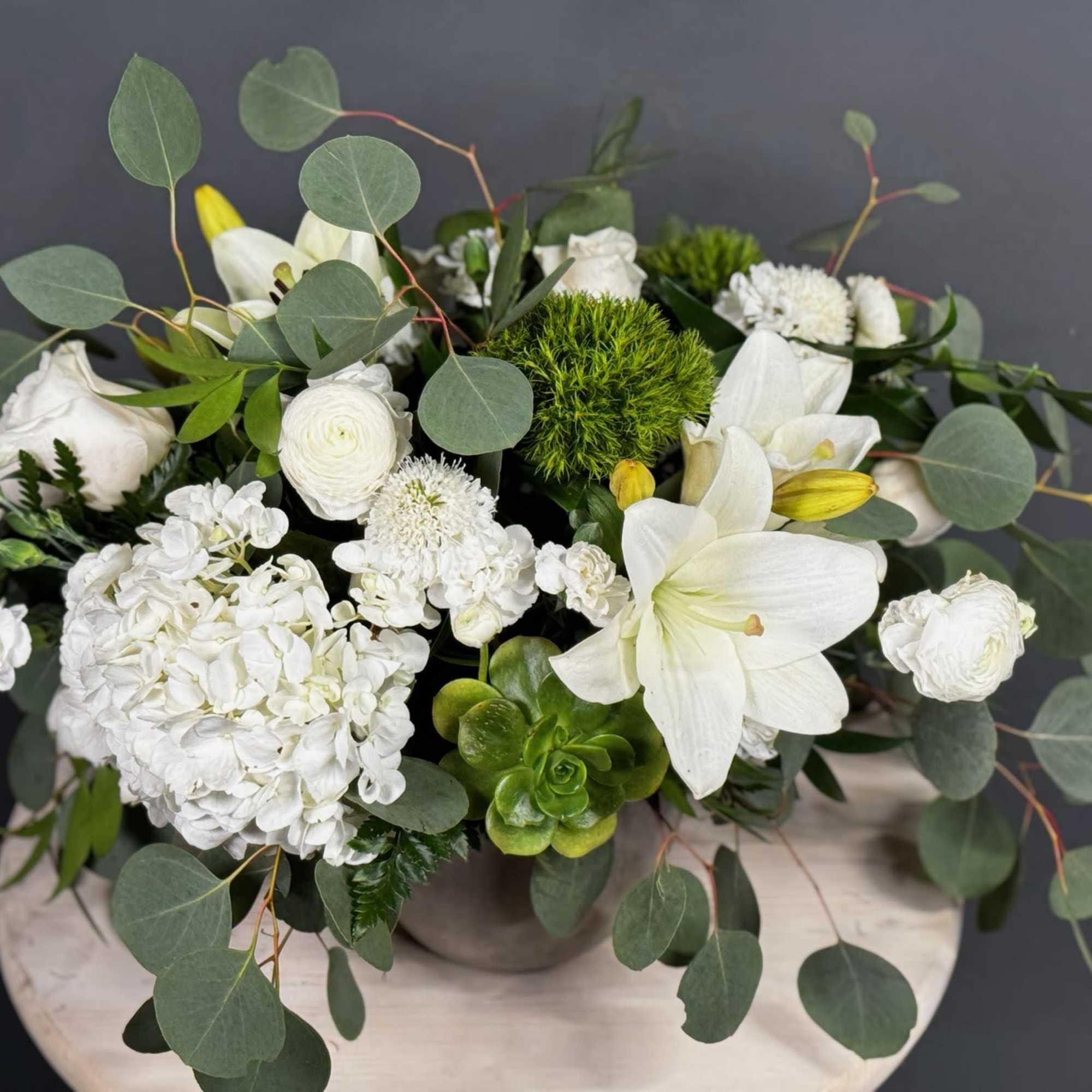 White floral arrangement with lilies, roses, and hydrangea in a vase