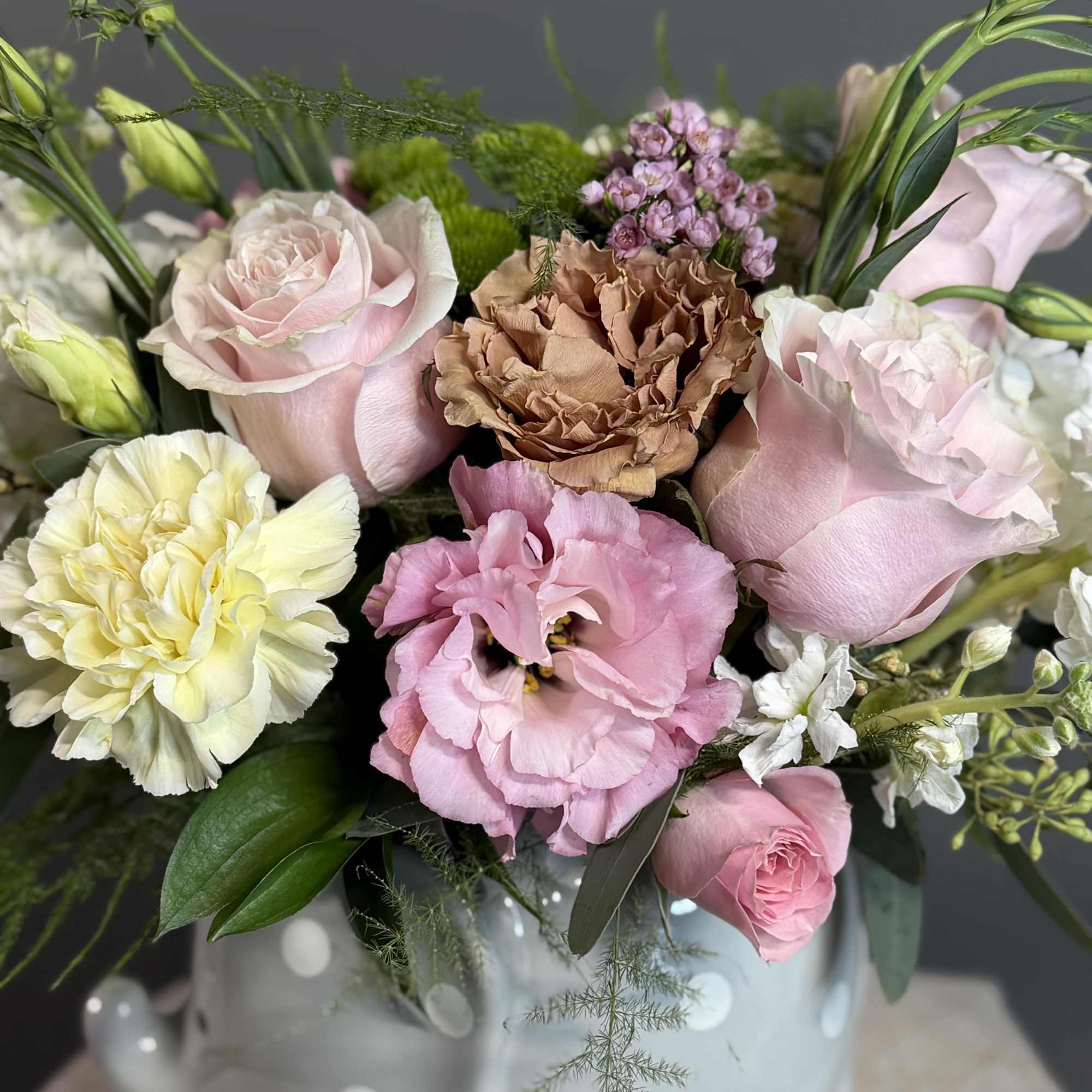 A sweet and delicate arrangement featuring soft pink blooms, creamy accents, and, photo 2 of 3