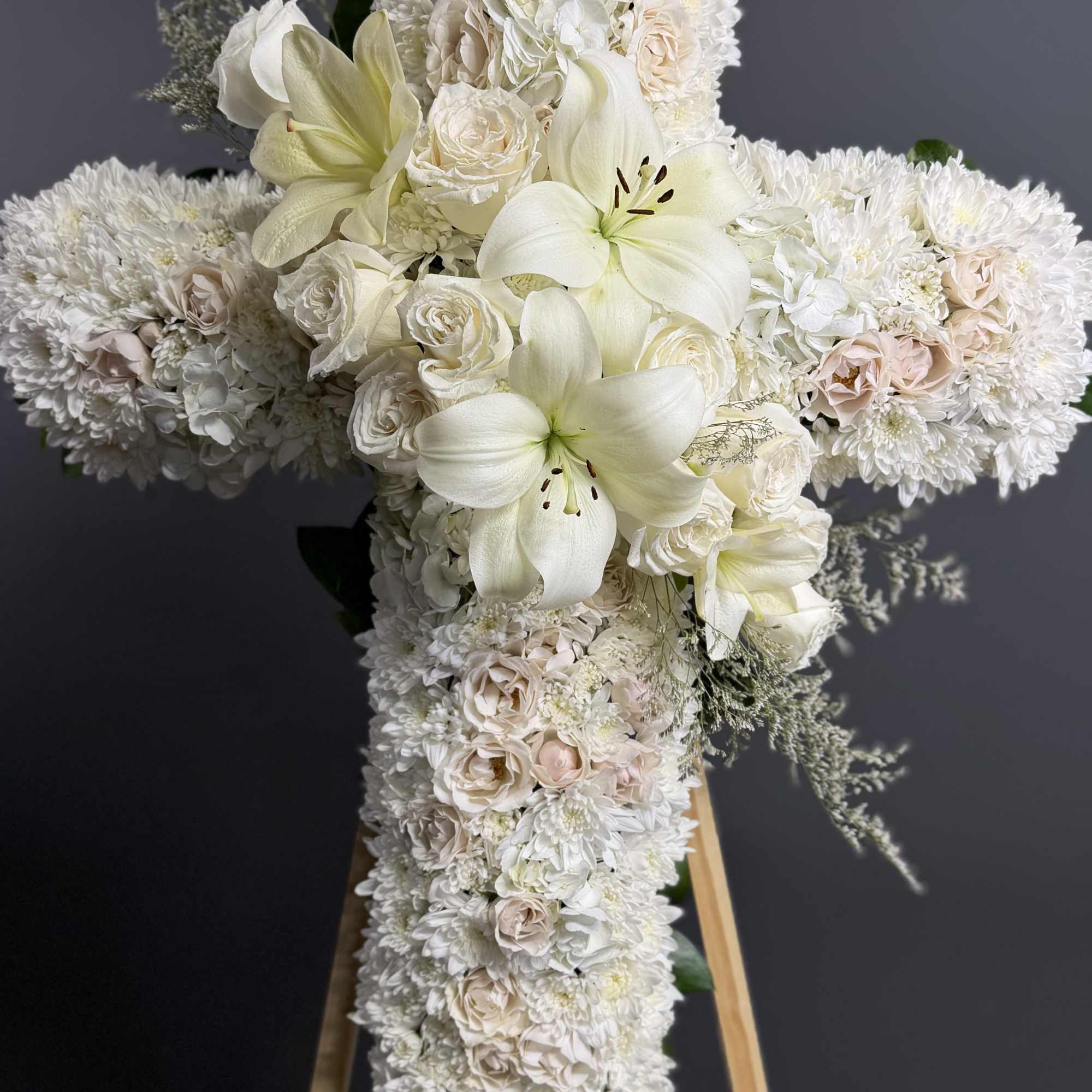An all white tribute, this white cross funeral spray is pure and