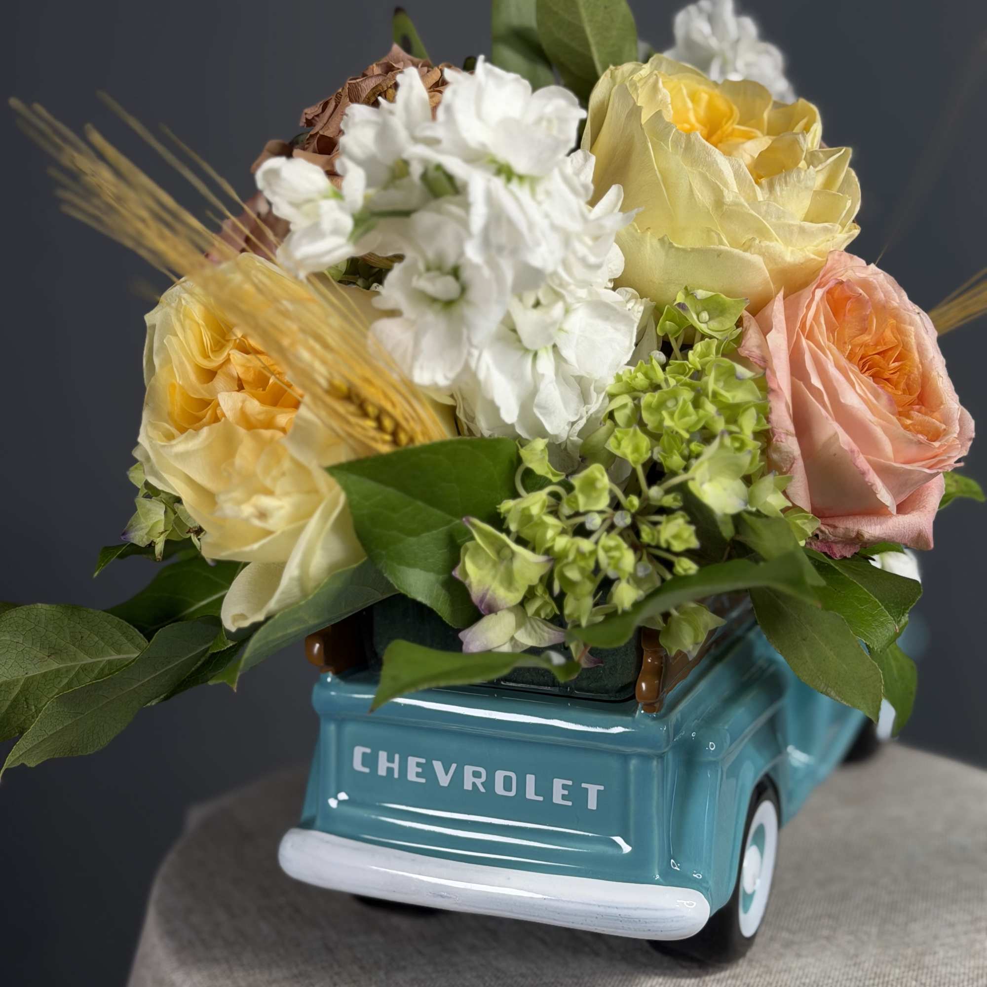 A glossy tale ceramic Ford pickup holds a cheerful, tightly packed cluster, photo 2 of 2