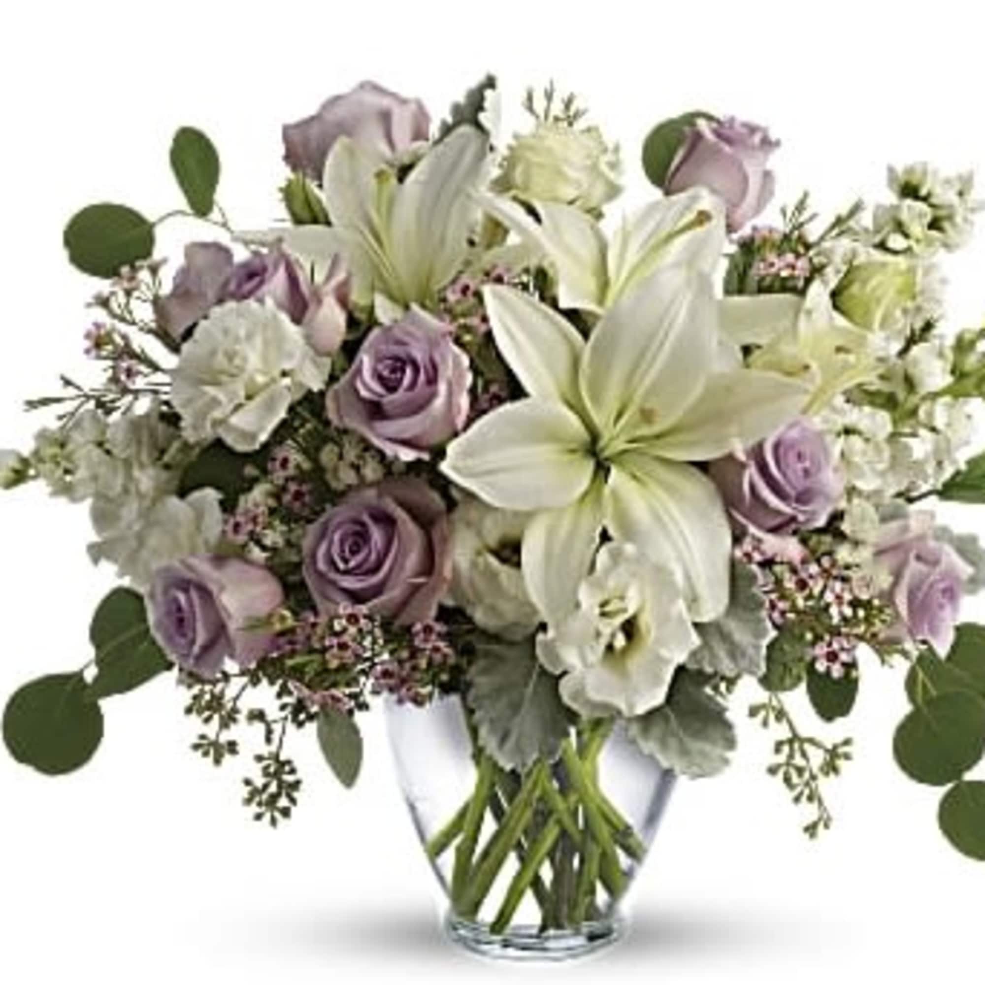 Lavender roses and white lilies arranged in a clear glass vase