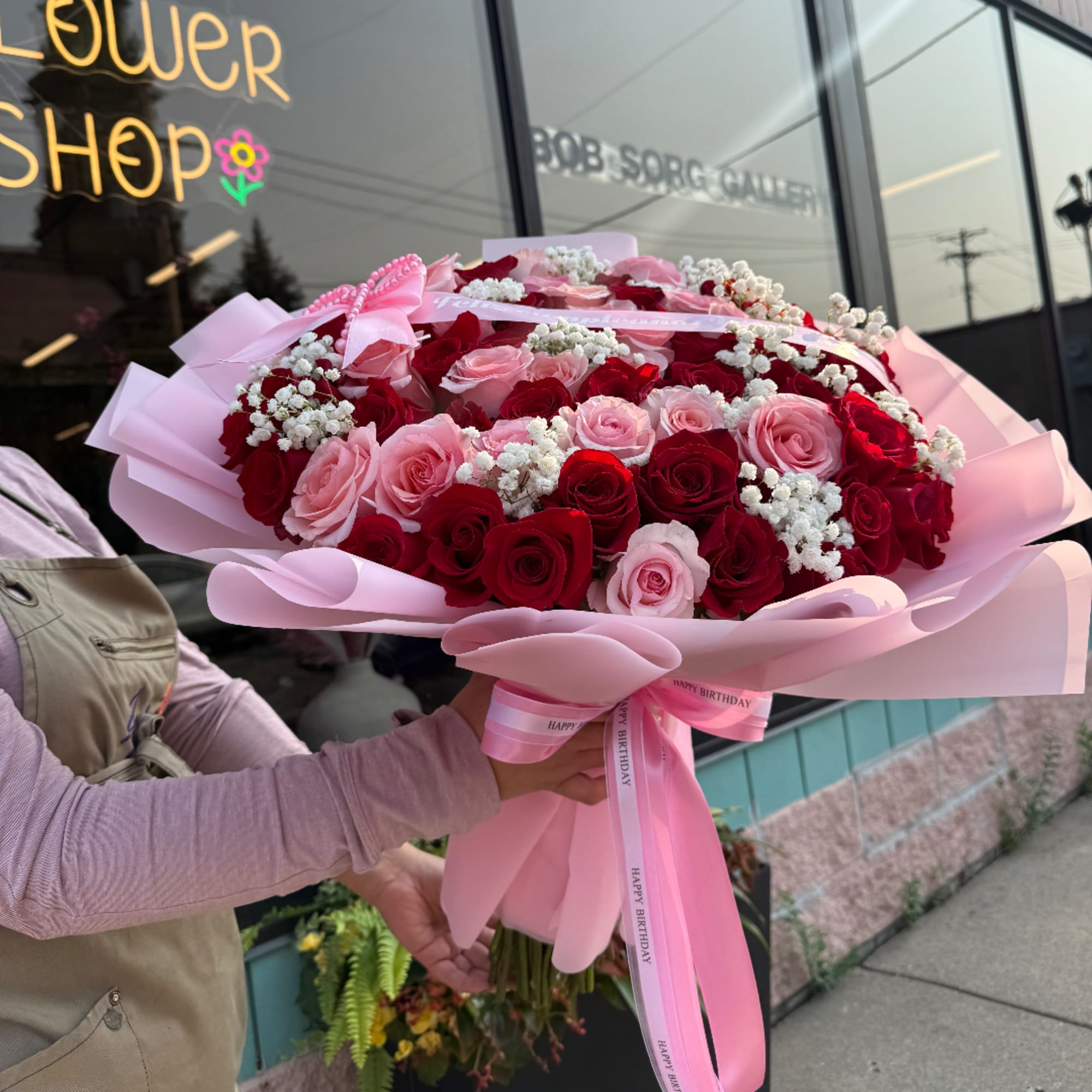 Large bouquet of red and pink roses wrapped in pink paper