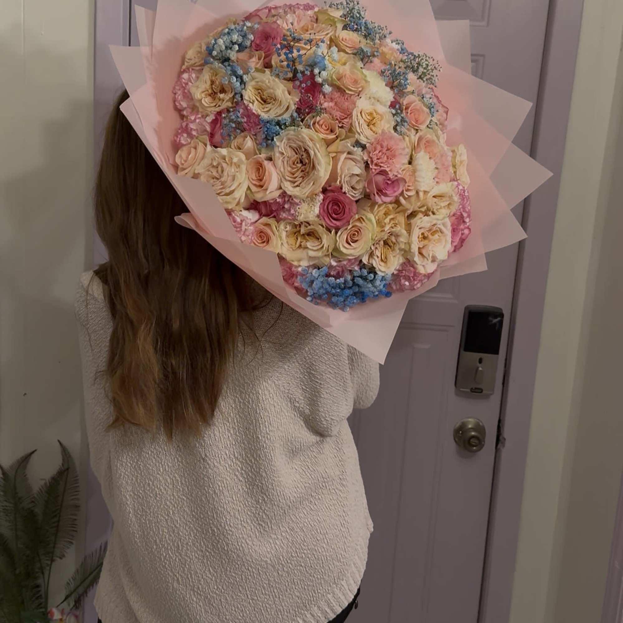 Large pastel bouquet of roses wrapped in pink paper