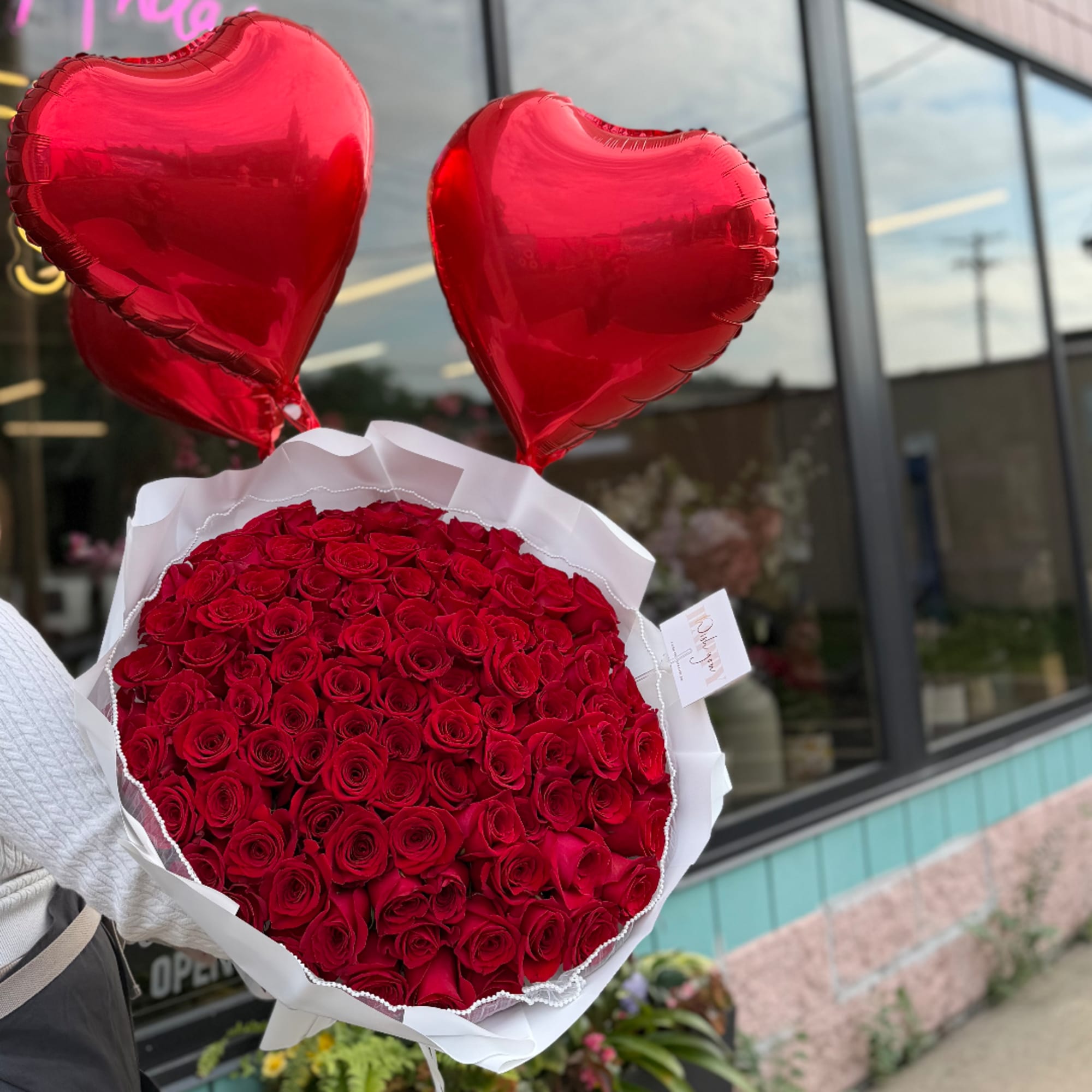 Bouquet of red roses with two red heart balloons