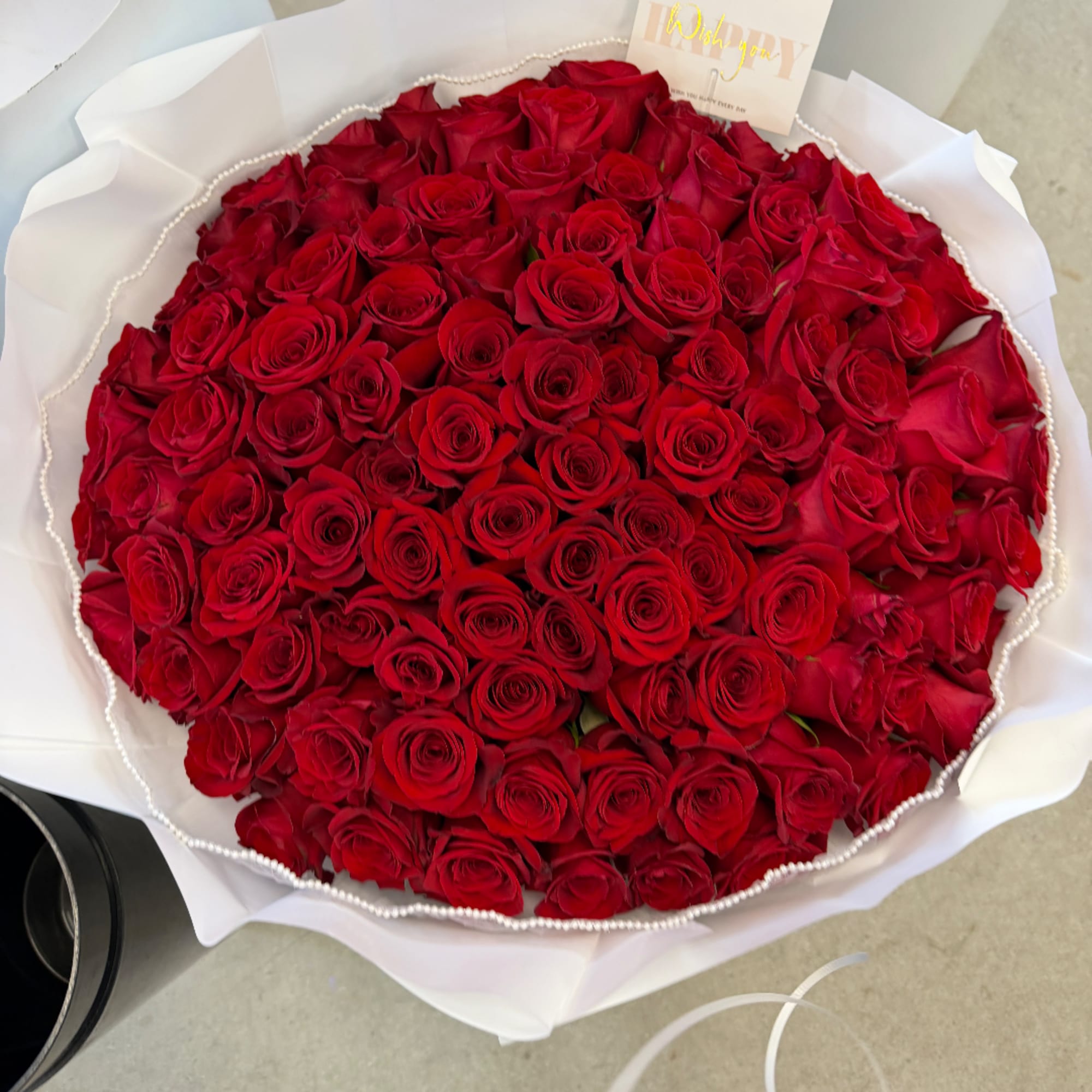 Large bouquet of red roses wrapped in white paper