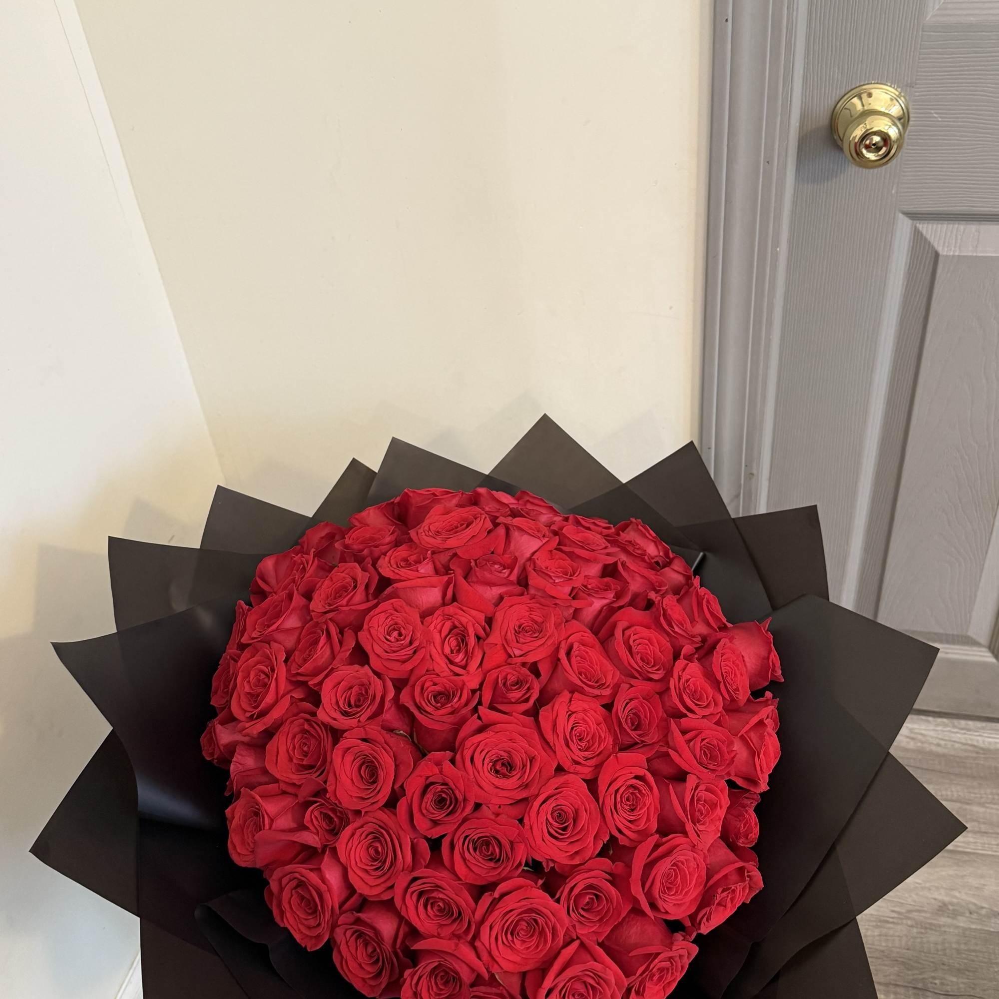 Large bouquet of red roses wrapped in black paper