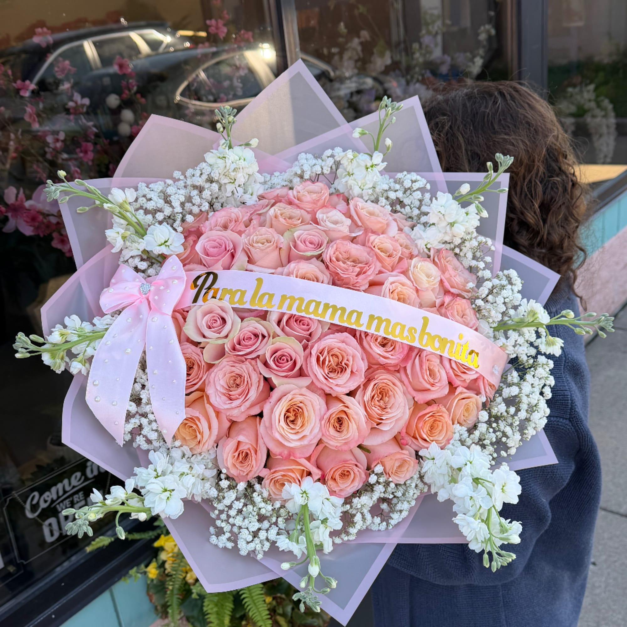 Large bouquet of pink roses with white filler flowers and a pink ribbon, photo 2 of 2