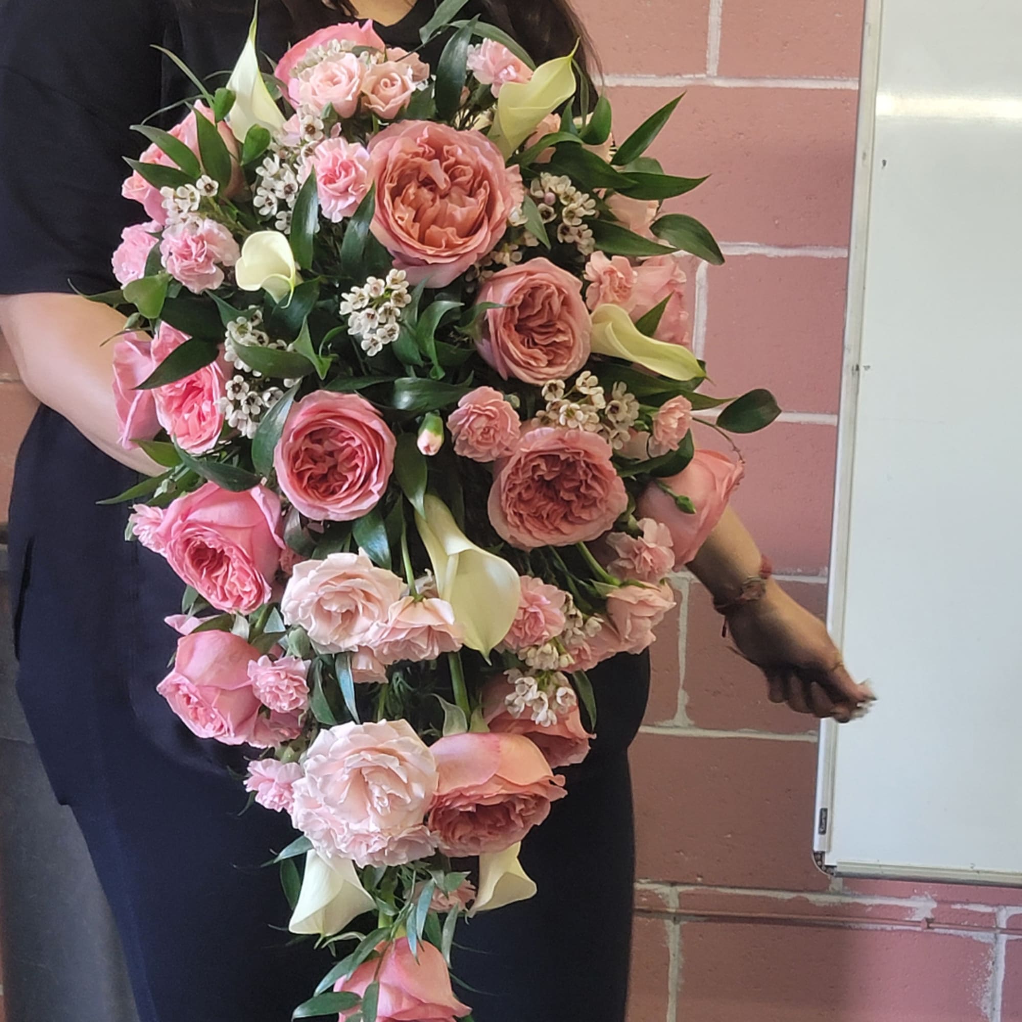 Large cascading bouquet of pink roses, carnations, and white calla lilies