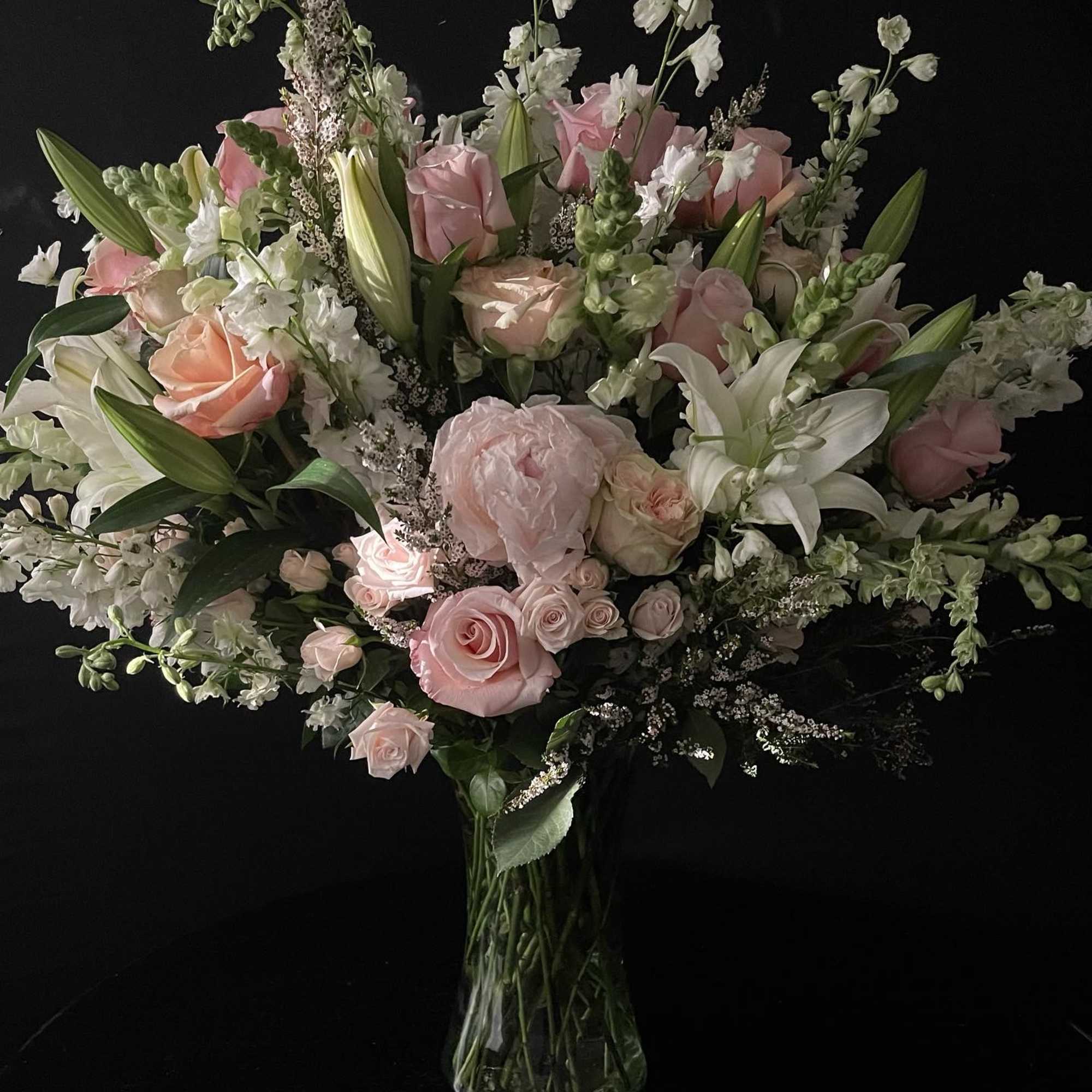 Pink and white floral arrangement in a clear glass vase